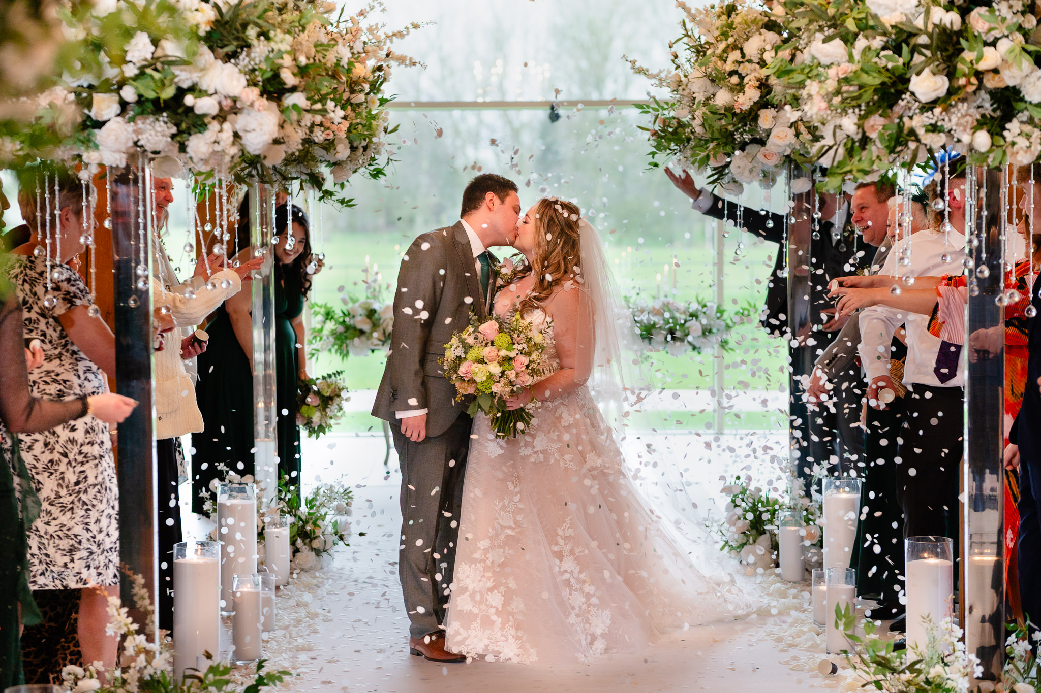 Newlyweds kissing under a shower of confetti at Merrydale Manor, Cheshire wedding photographer