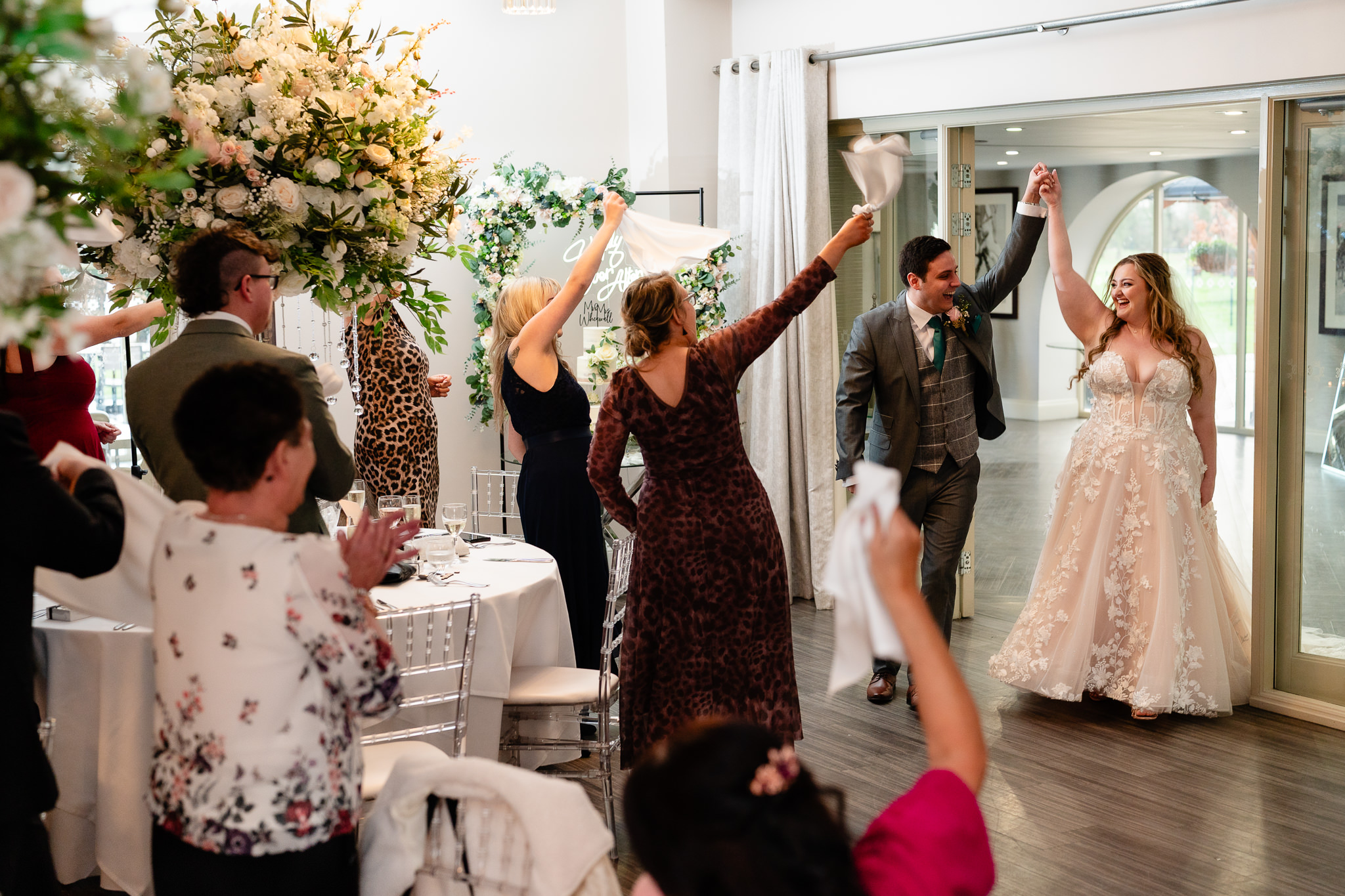 Bride and groom entering their wedding reception to cheering guests at Merrydale Manor