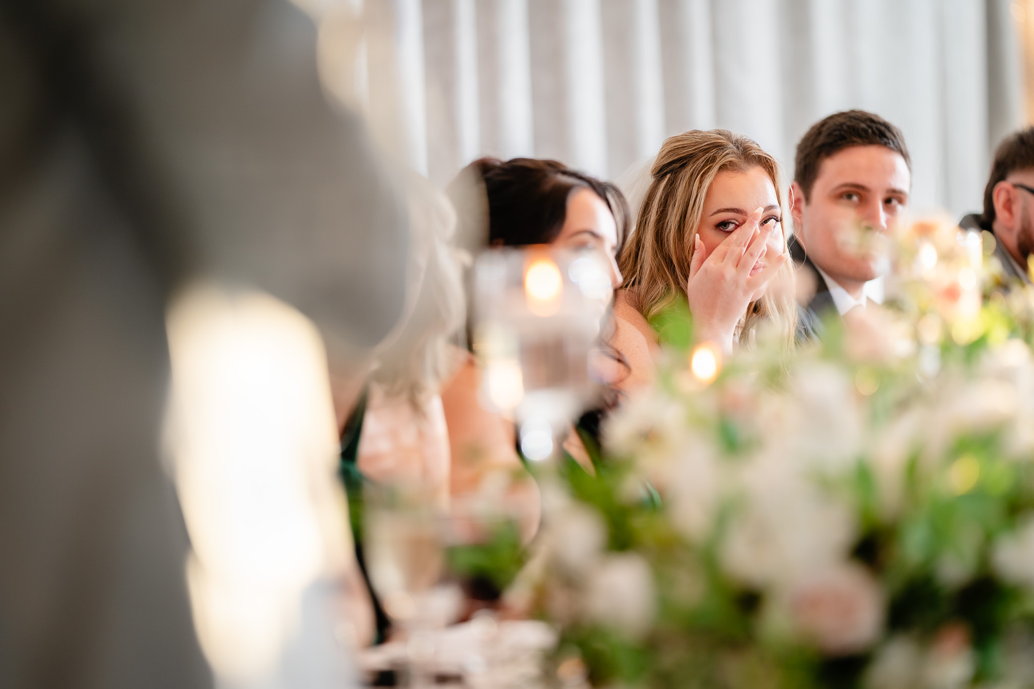 Bridesmaid wiping away a tear during an emotional wedding speech at Merrydale Manor