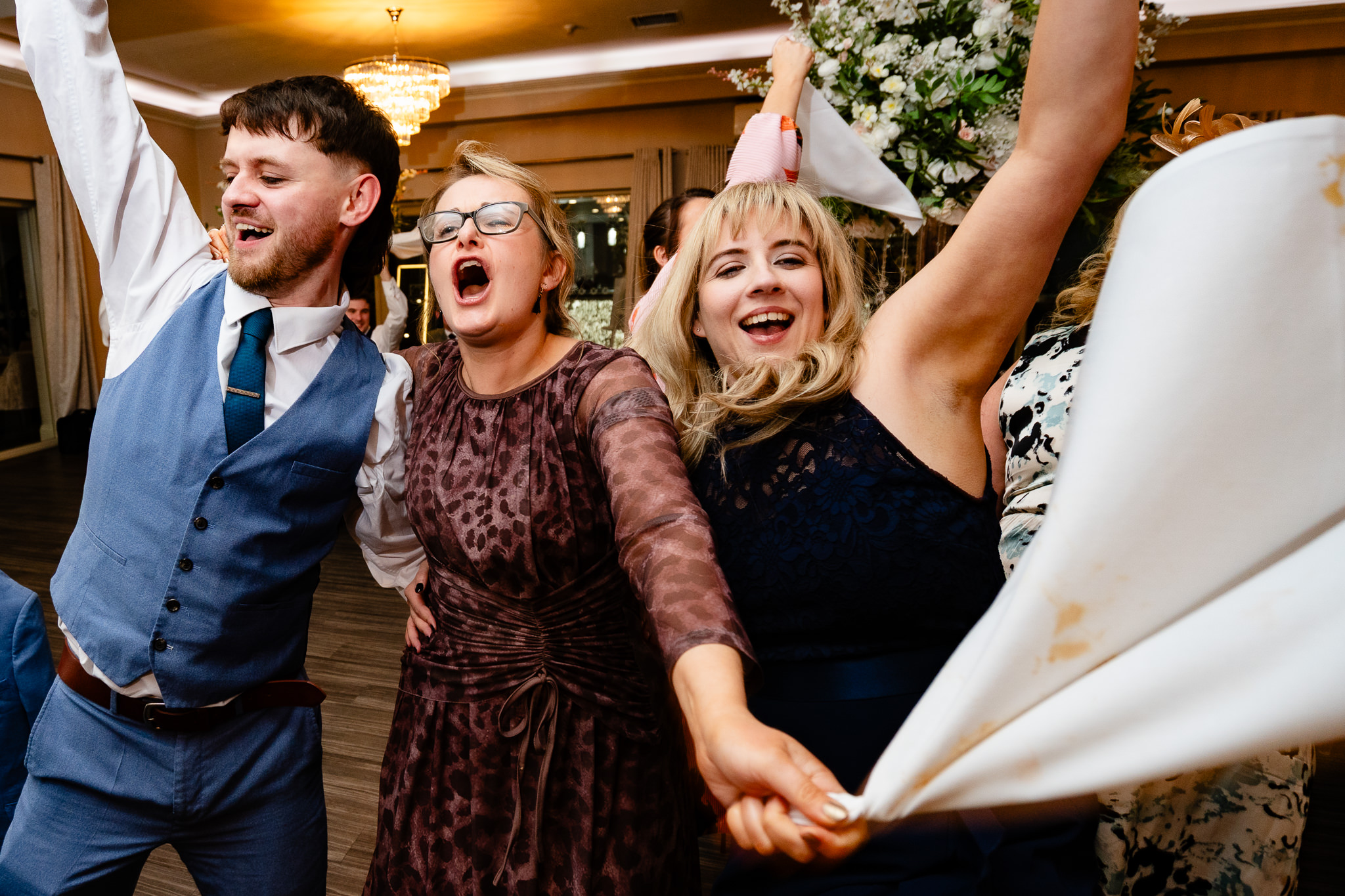 Wedding guests waving napkins in the air during the Singing Waiters performance at Merrydale Manor