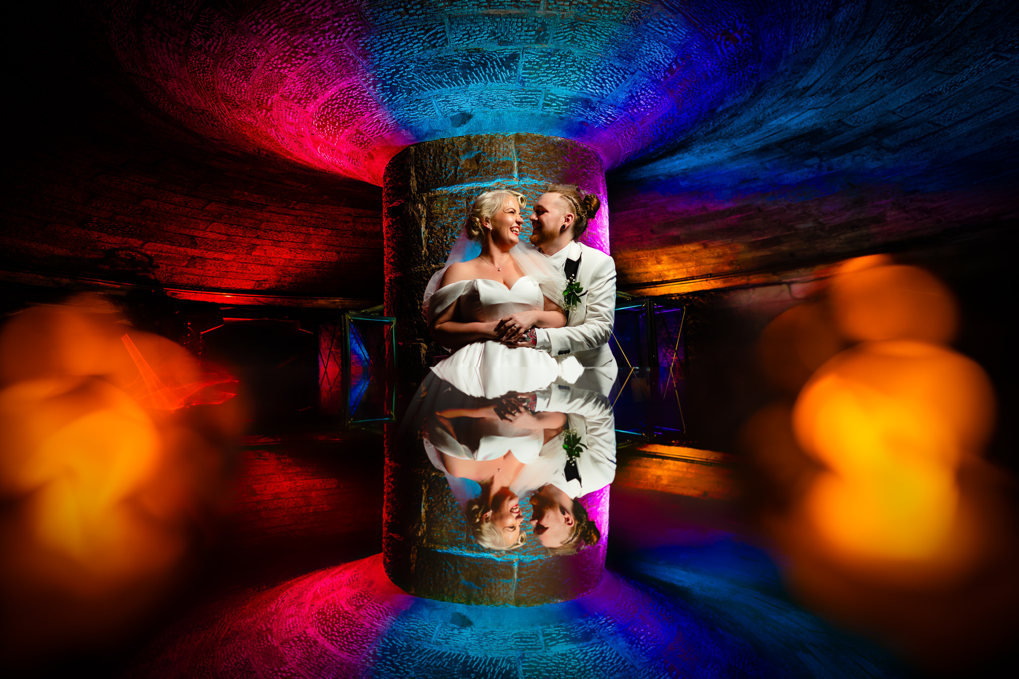 Creative flash wedding photograph of a couple at Peckforton Castle, lit with coloured gels and a prism effect