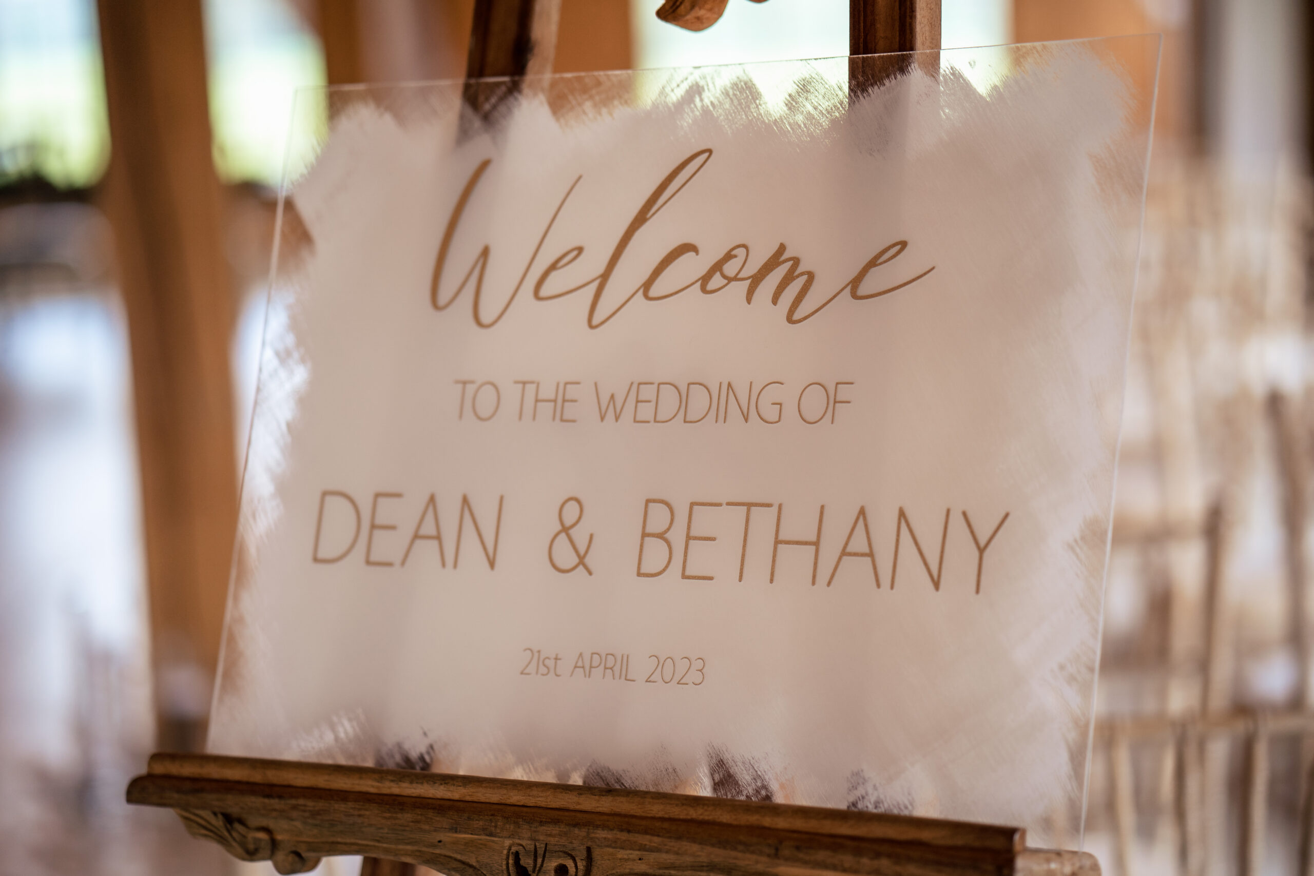 Acrylic welcome sign reading Welcome to the wedding of Dean and Bethany on an easel at Merrydale Manor