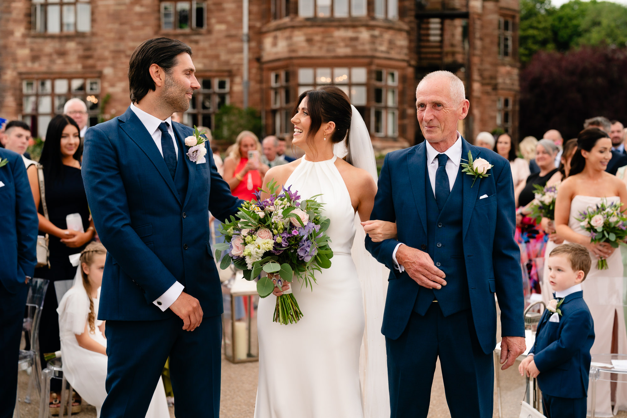 Bride walking down the aisle on her father's arm to meet her groom at Salt House, Staffordshire wedding photographer