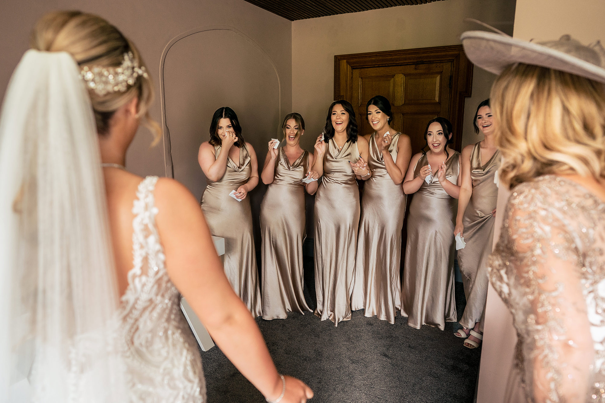 Bridesmaids reacting with delight as Jess turns around in her wedding dress before her Salt House wedding, Staffordshire