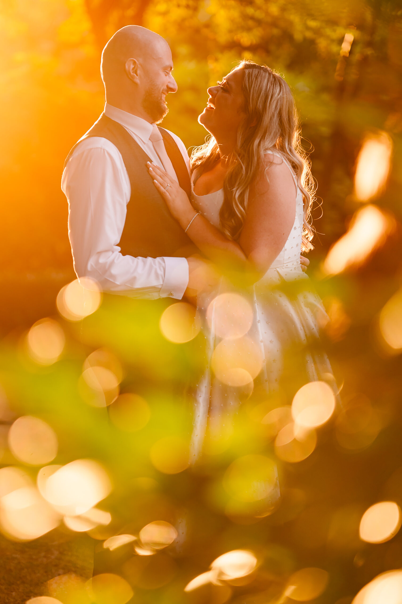 Chloe and Pete forehead to forehead in golden evening light at Wrenbury Hall, Cheshire wedding photographer
