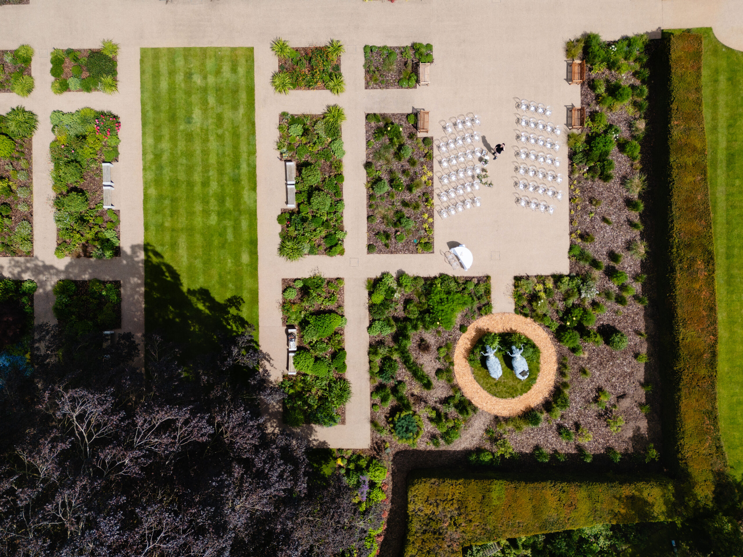 Aerial view of the gardens at Salt House set up with rows of white chairs for an outdoor wedding ceremony