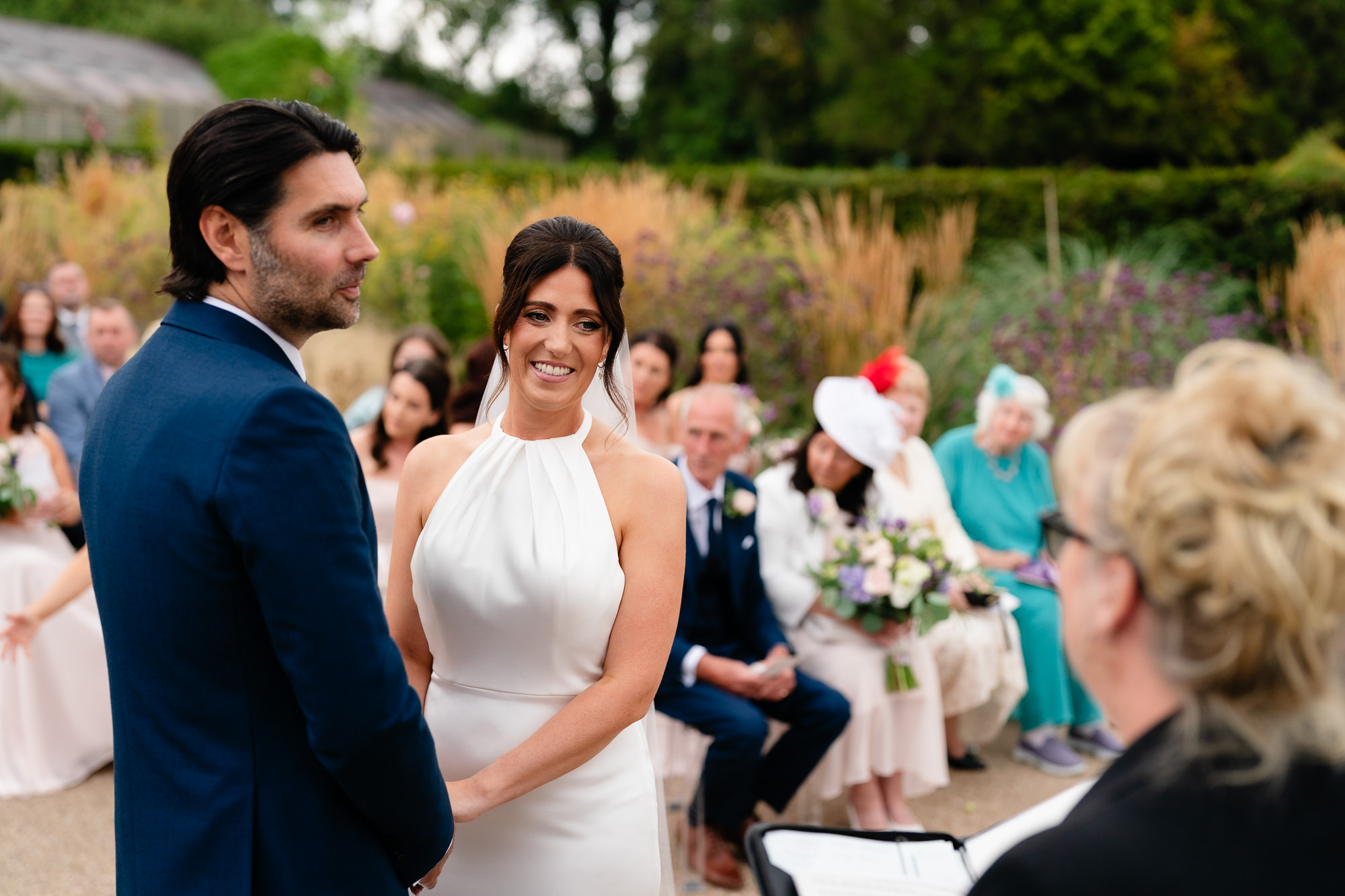 Bride and groom smiling at each other during their outdoor ceremony at Salt House, Staffordshire wedding photographer