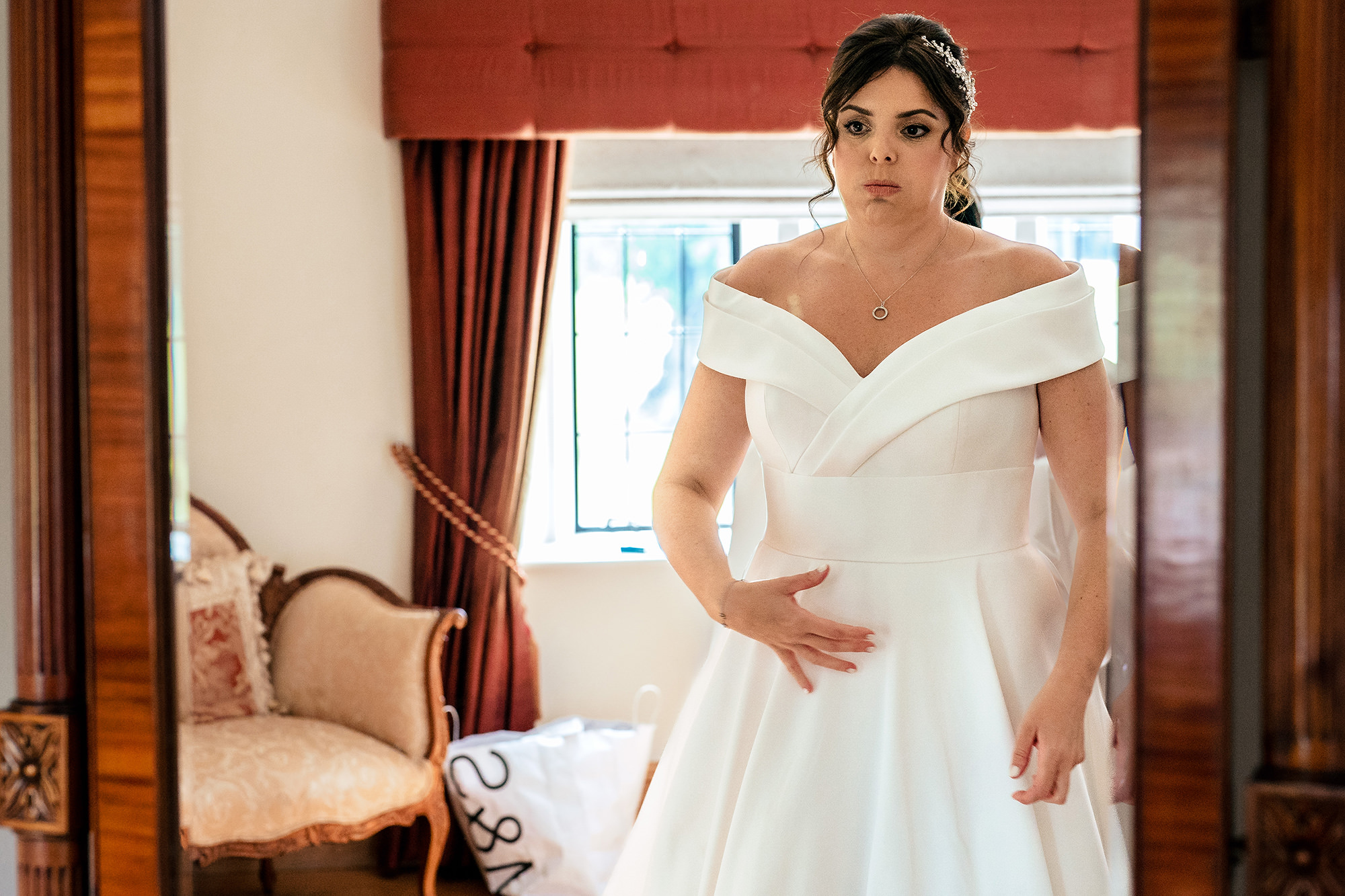 Laura checking her reflection in the mirror during getting ready, Merrydale Manor wedding photographer