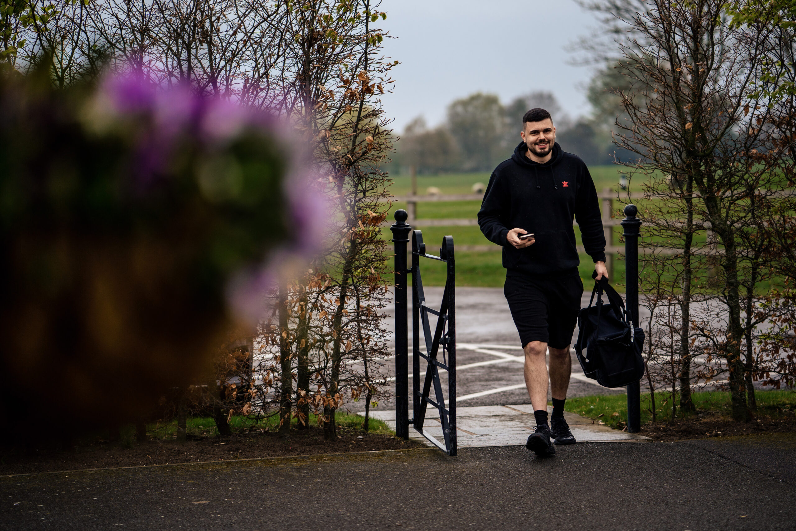 Dean arriving at Merrydale Manor on the wedding morning in a black hoodie, carrying his bag