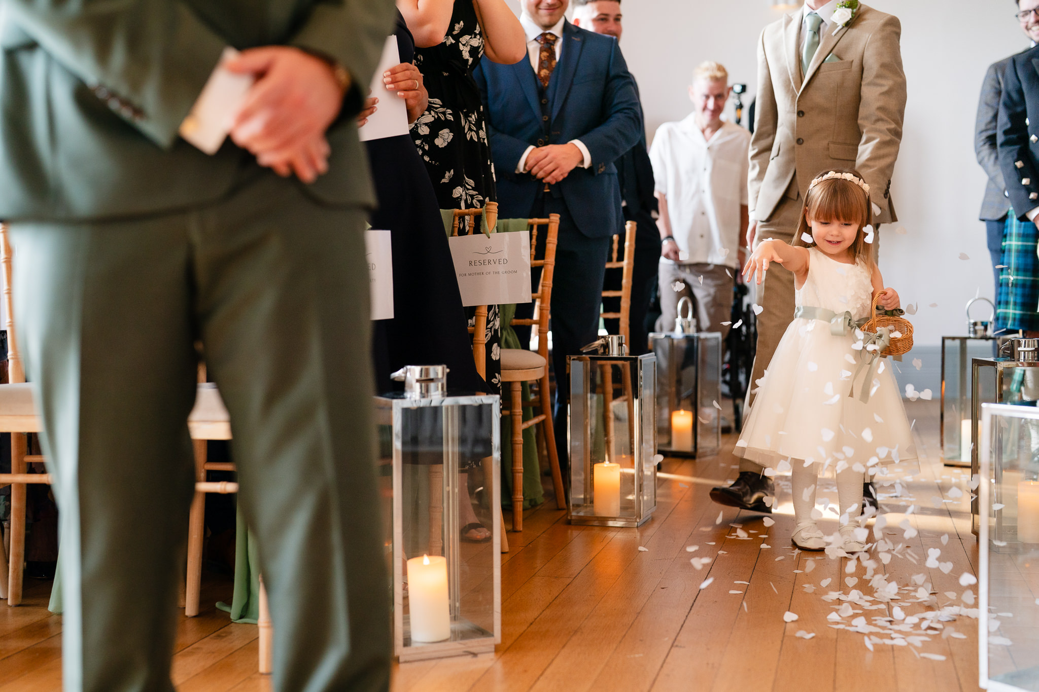 Flower girl scattering petals down the aisle as guests wait for the ceremony to begin at Salt House