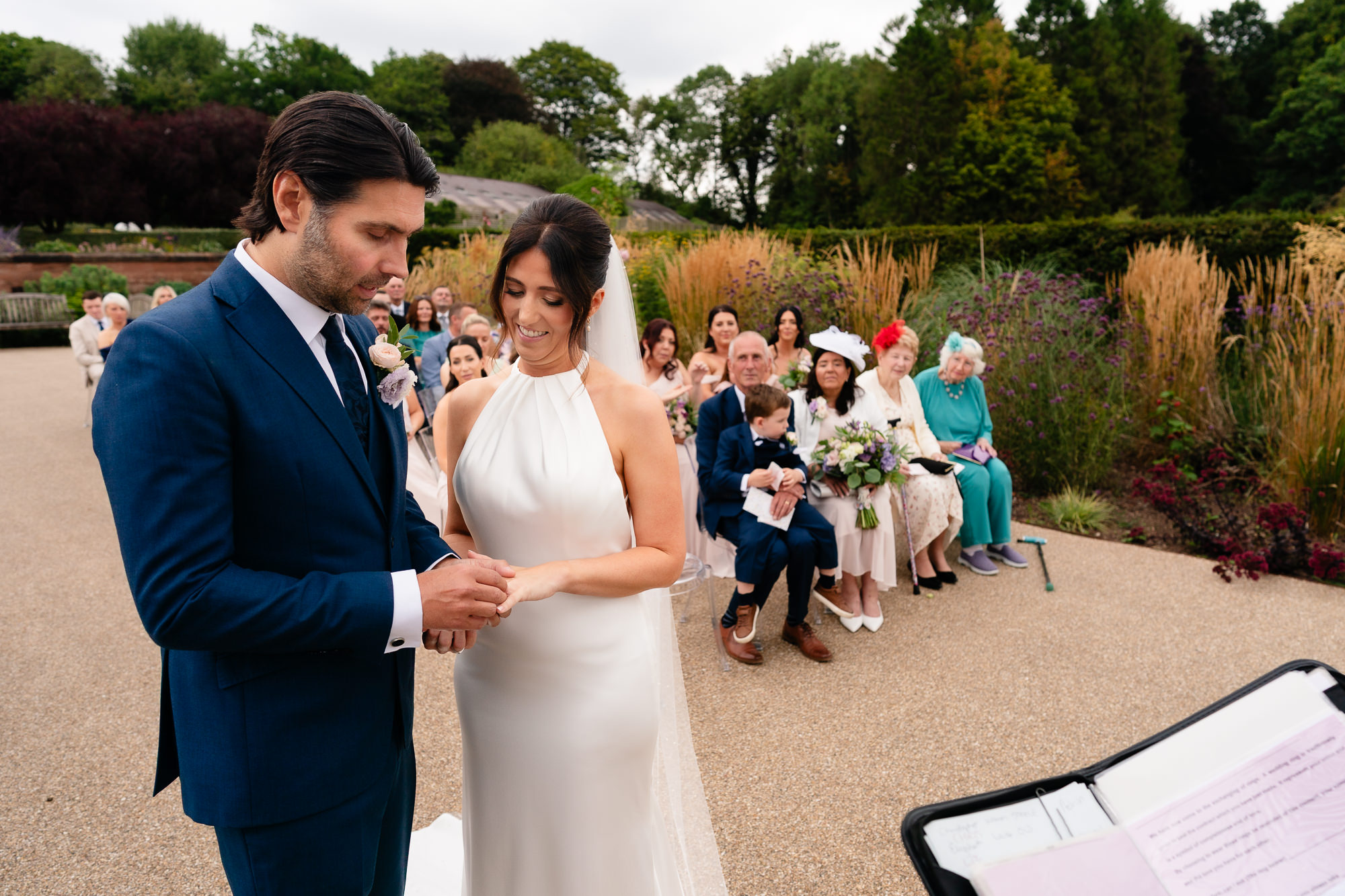 Groom placing the wedding ring on his bride's finger during the ceremony, Salt House Staffordshire wedding photographer