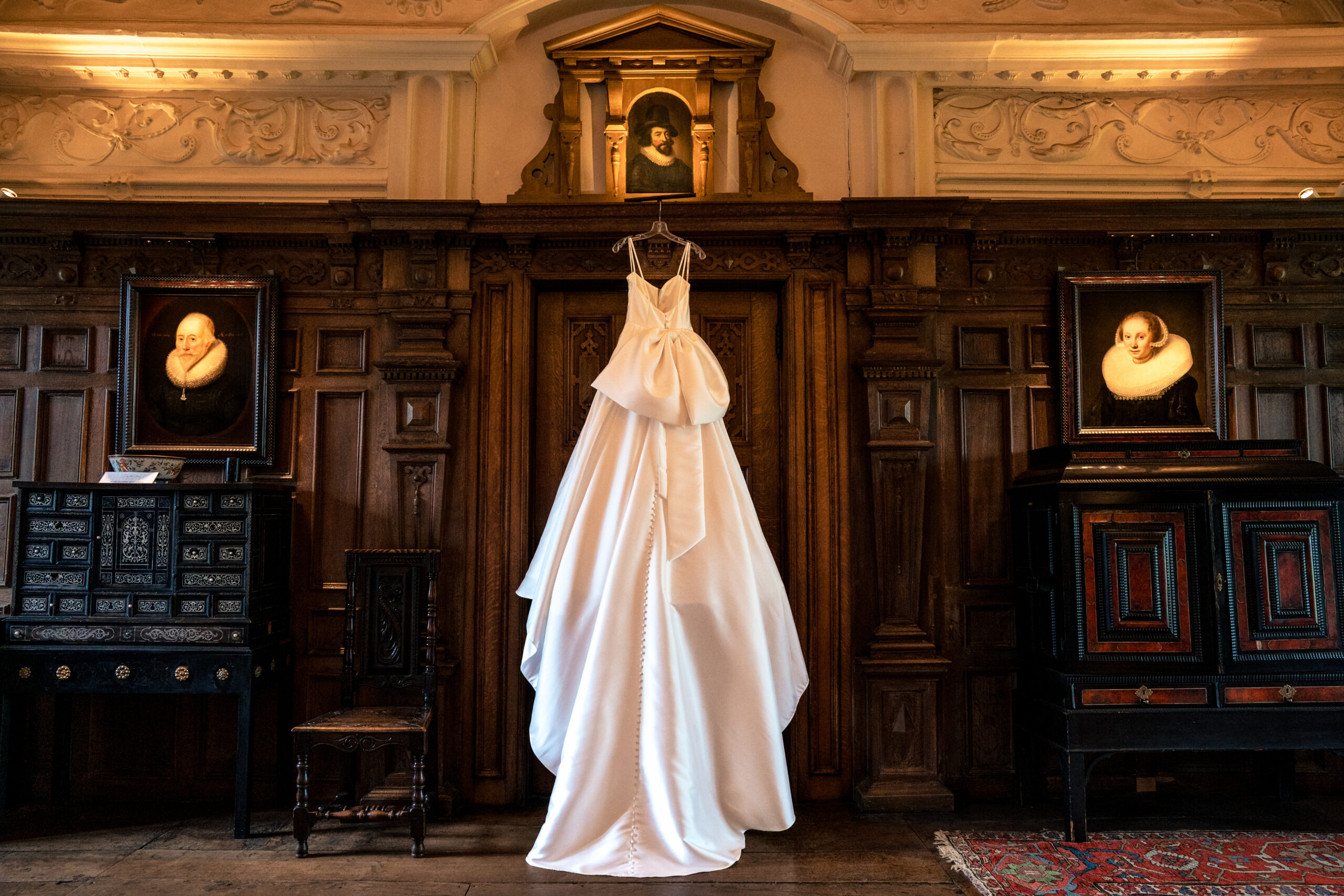 Martina Liana wedding dress hanging in the oak panelled room at Dorfold Hall