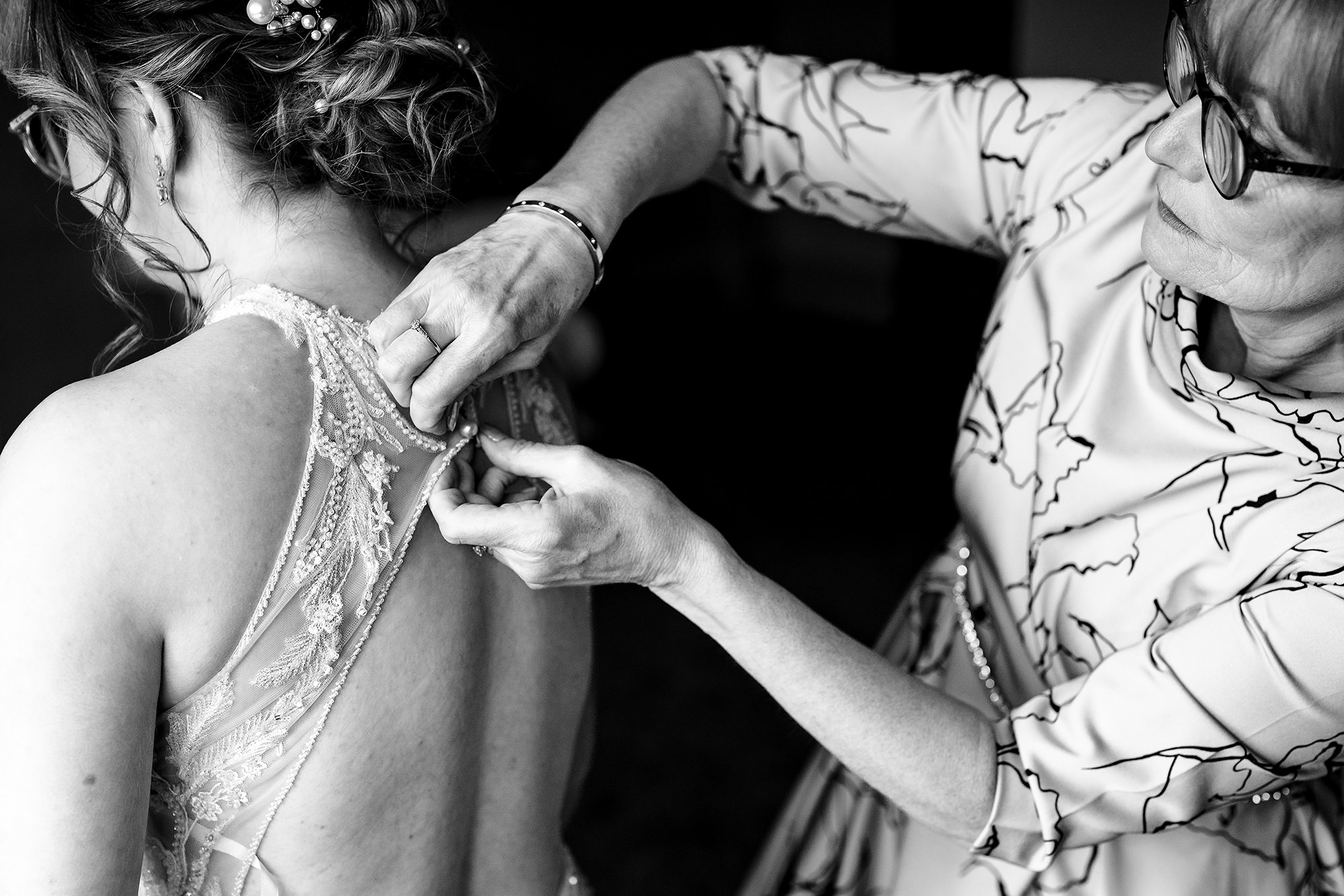 Bride’s mum fastening the back of her dress, black and white, Salt House wedding photographer