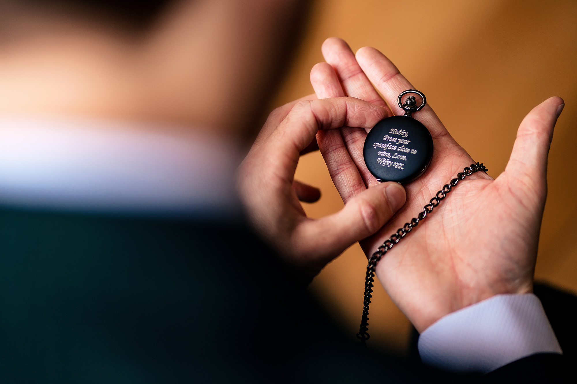 Groom holding an engraved pocket watch with a Bowie lyric inscription before his Standon Hall wedding