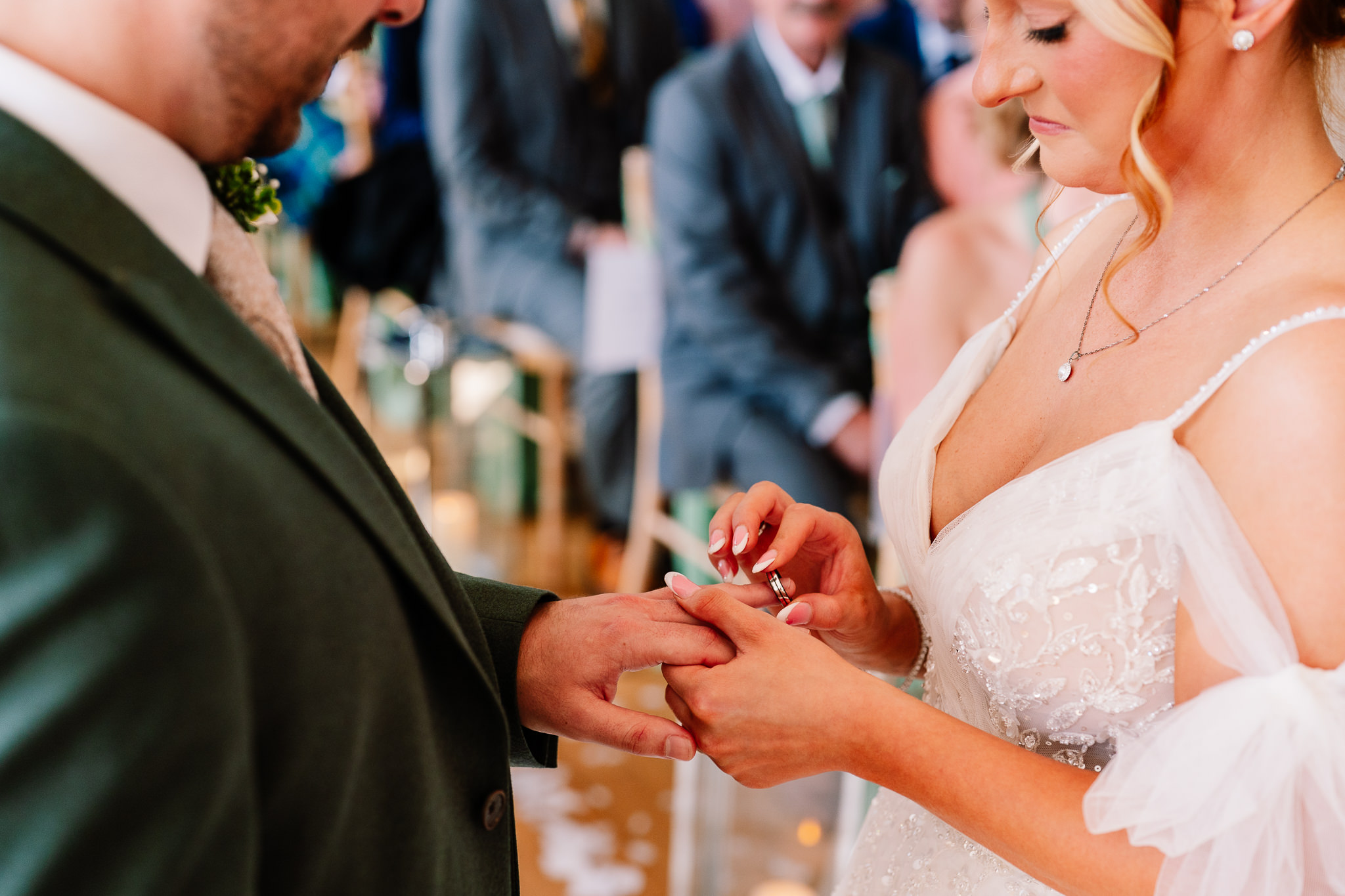 Close up of the bride and groom holding hands during the ring exchange