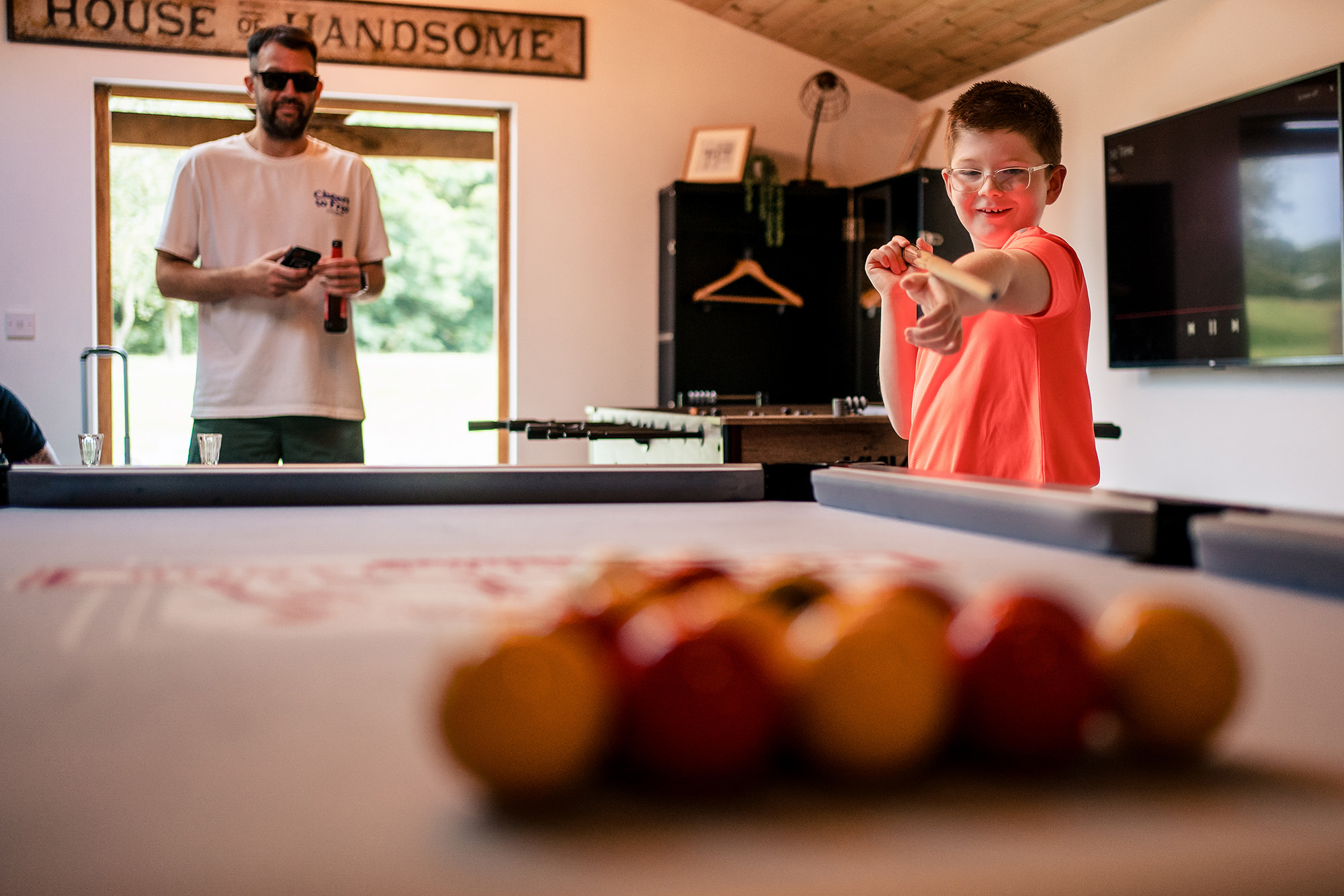 The youngest member of the wedding party taking a turn at the pool table, Merrydale Manor wedding photographer