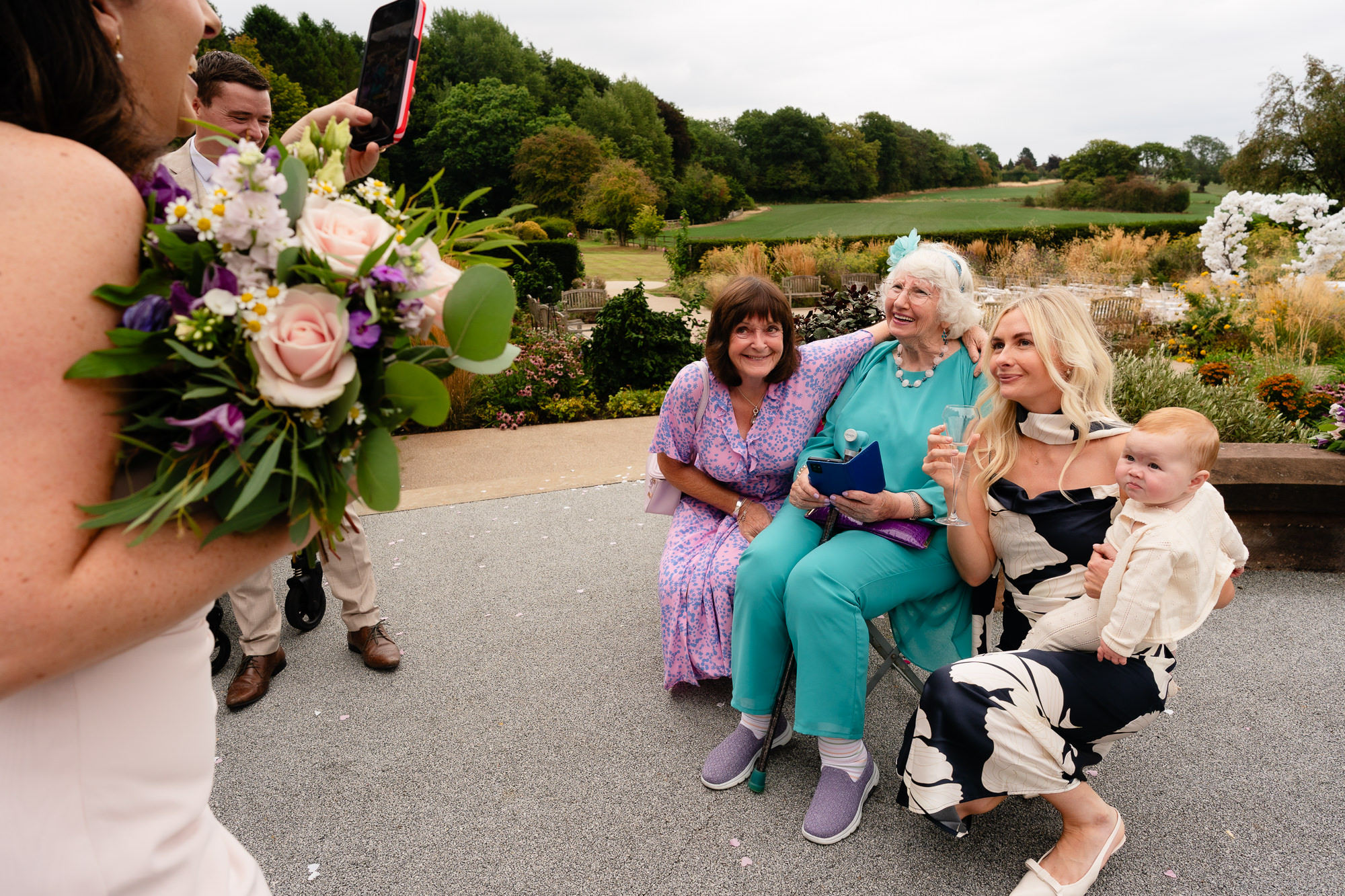 Guests celebrating with champagne in the gardens at Salt House, Staffordshire wedding photographer