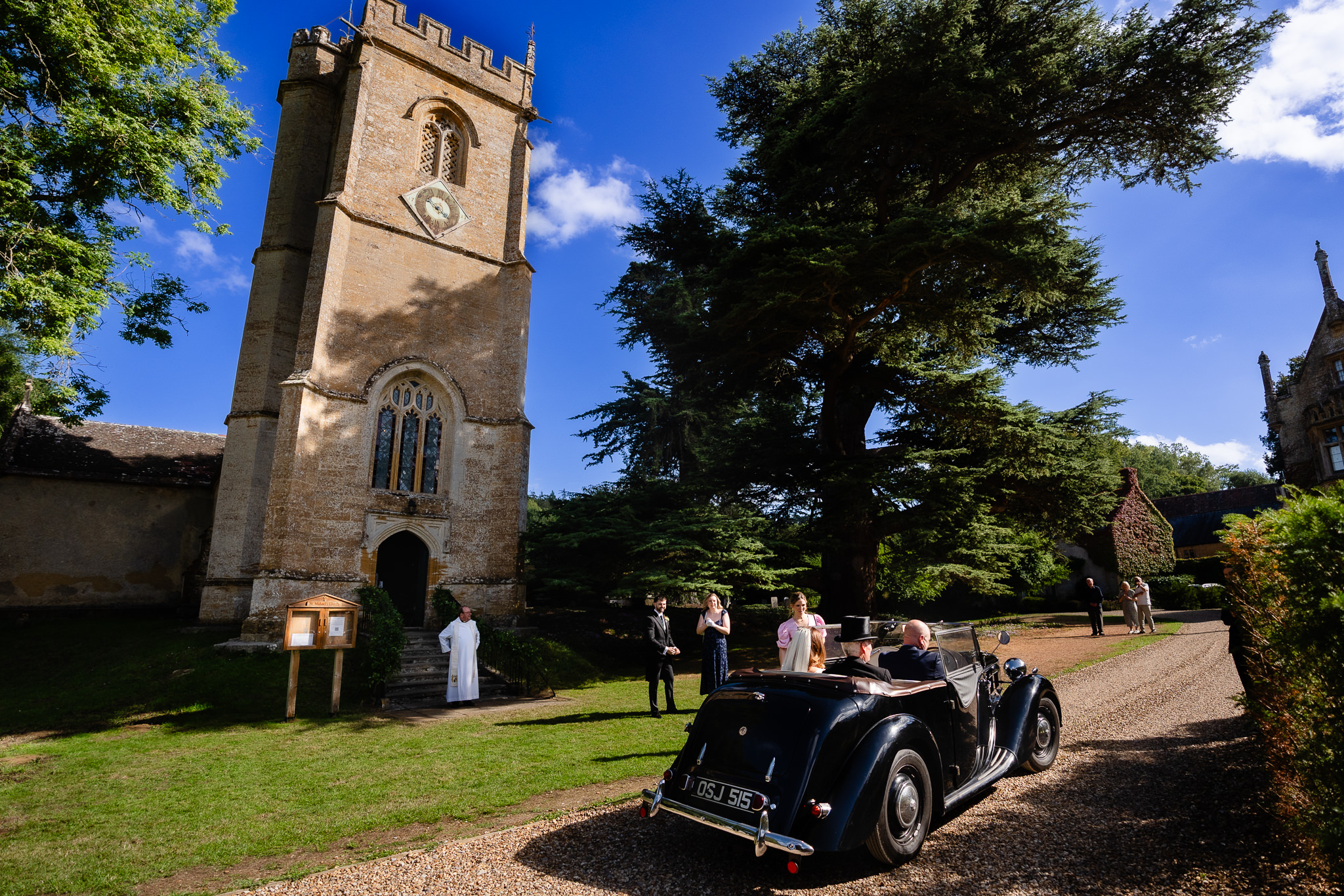 Vintage car parked outside the village church ahead of the wedding ceremony, Dorset marquee wedding photographer