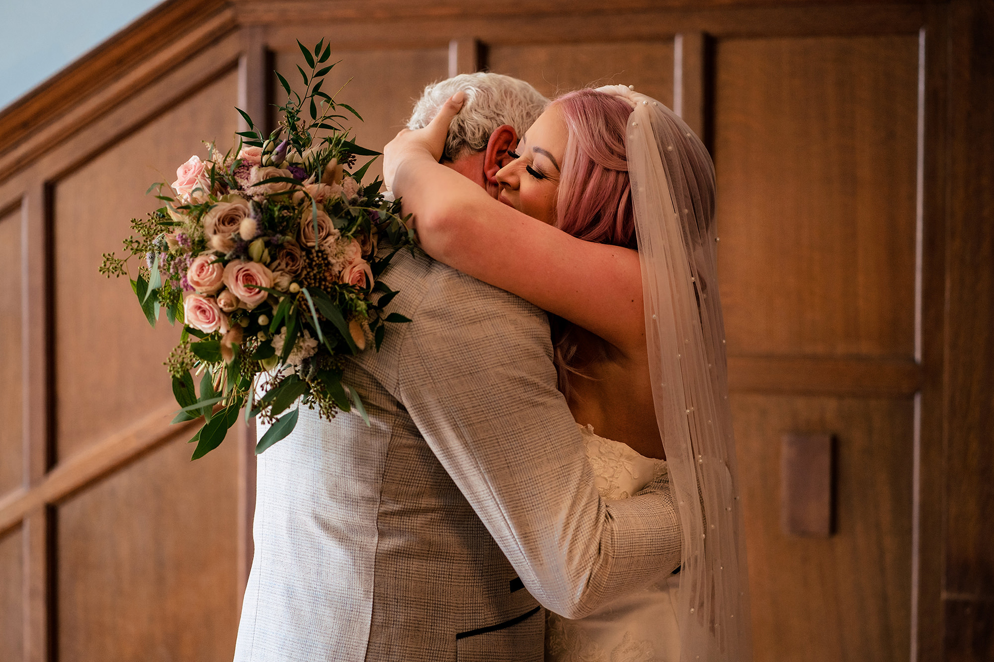 Bride hugging her dad in her veil before walking down the aisle at Standon Hall