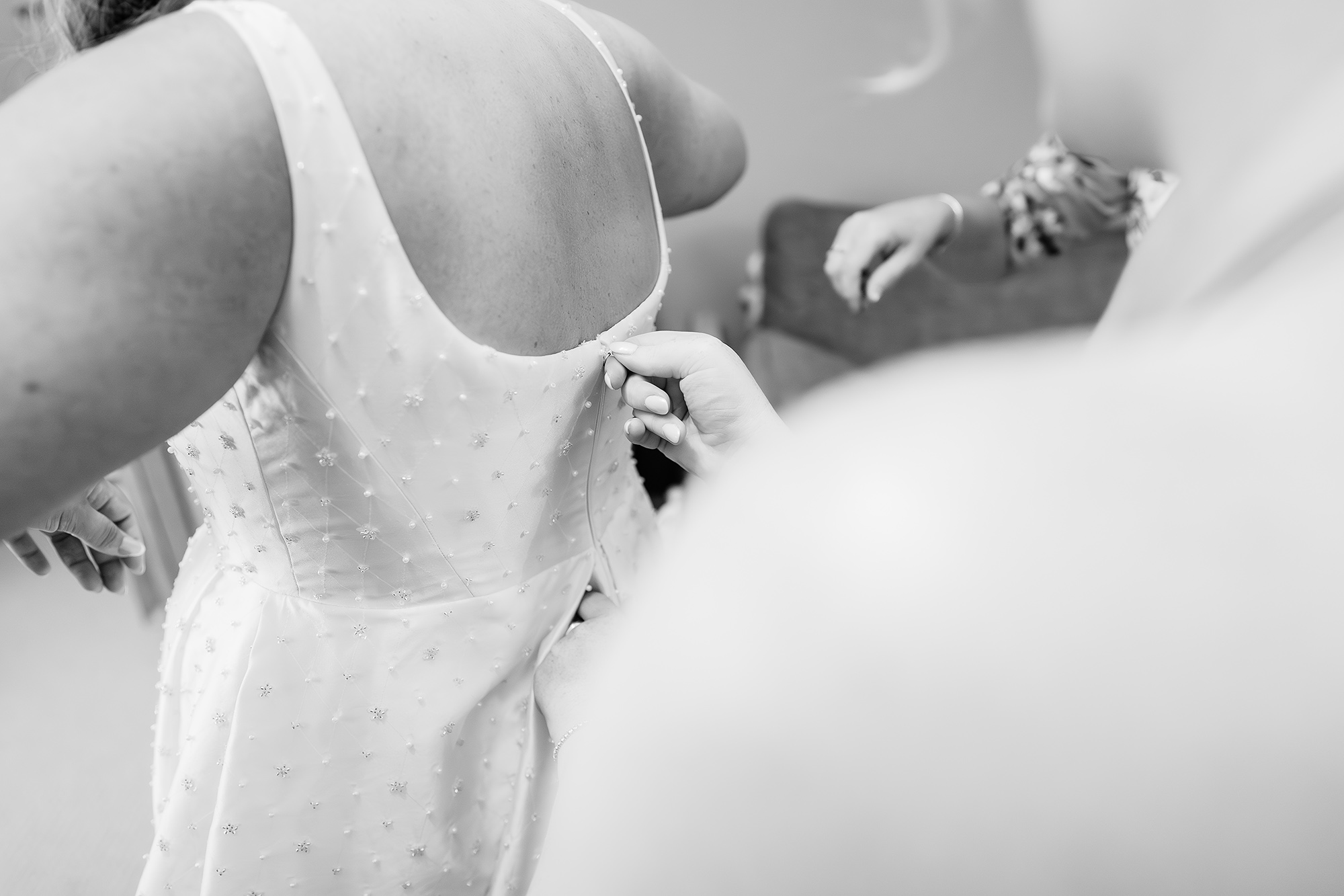 Black and white detail of Chloe’s dress and veil down her back