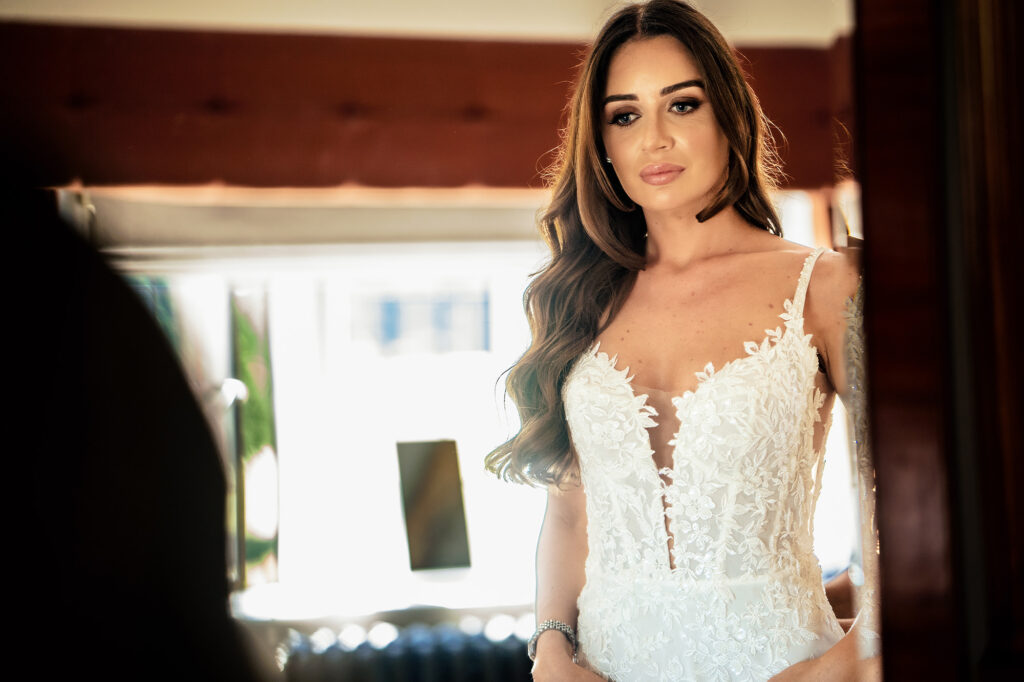 Gemma in her Emma Beaumont lace wedding dress, seen in a mirror at Merrydale Manor