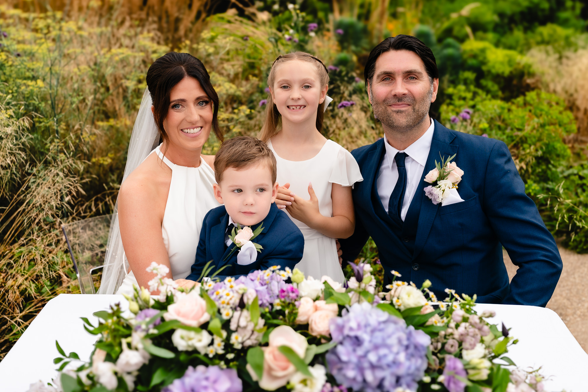 Bride and groom with their two children in the gardens at Salt House, Staffordshire wedding photographer