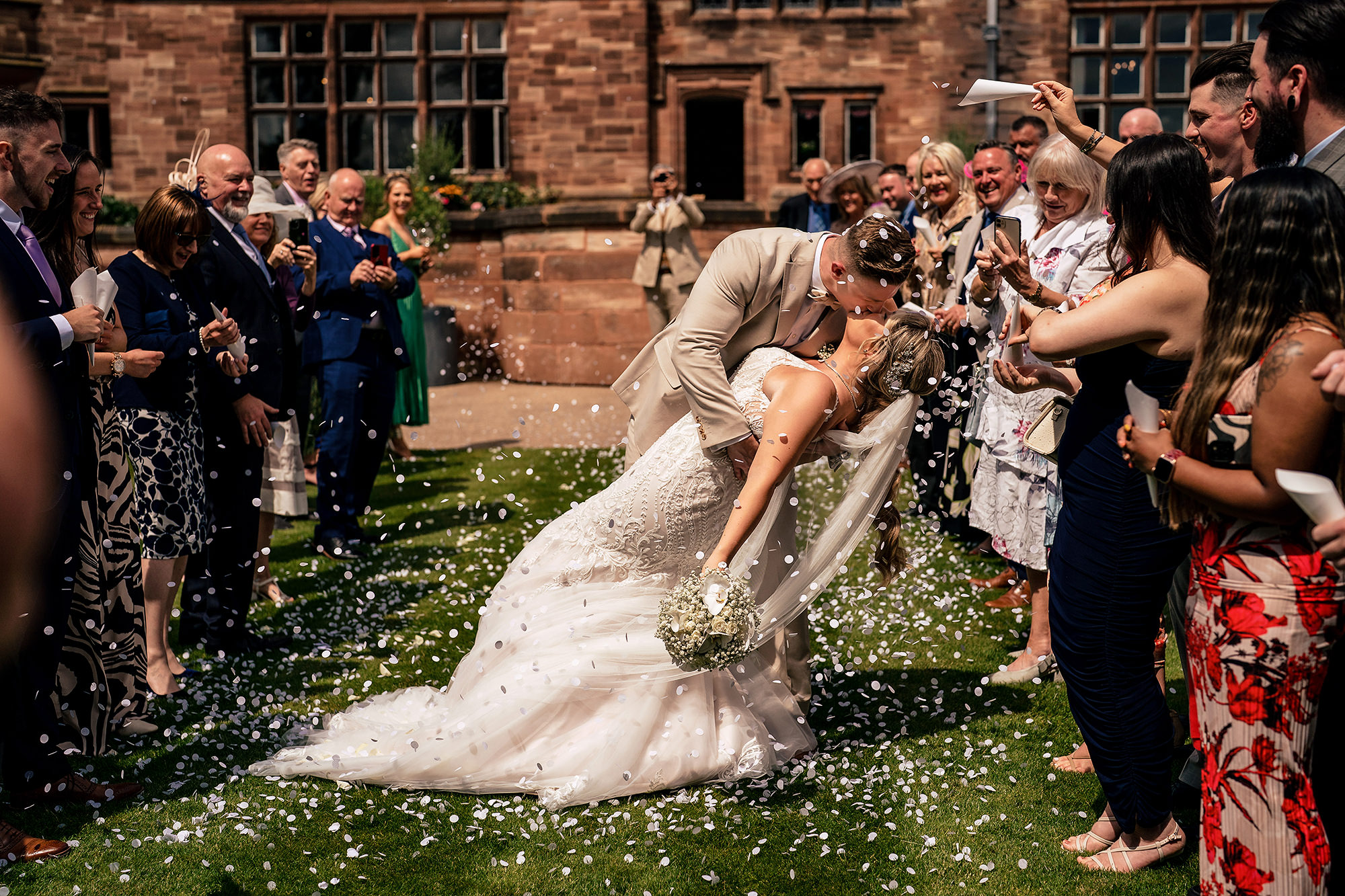 A confetti dip kiss outside Salt House’s sandstone building, Staffordshire wedding photography