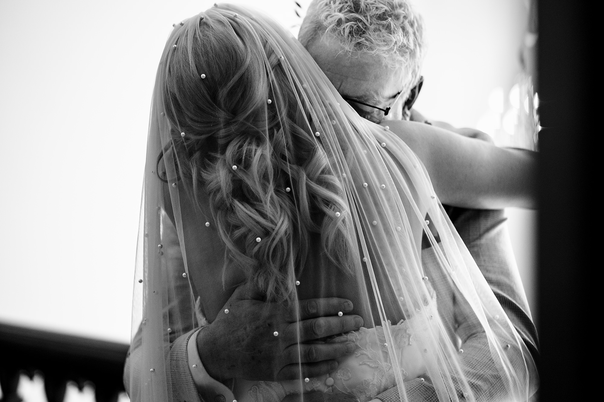 Black and white close up of a bride and her dad hugging before her Standon Hall wedding