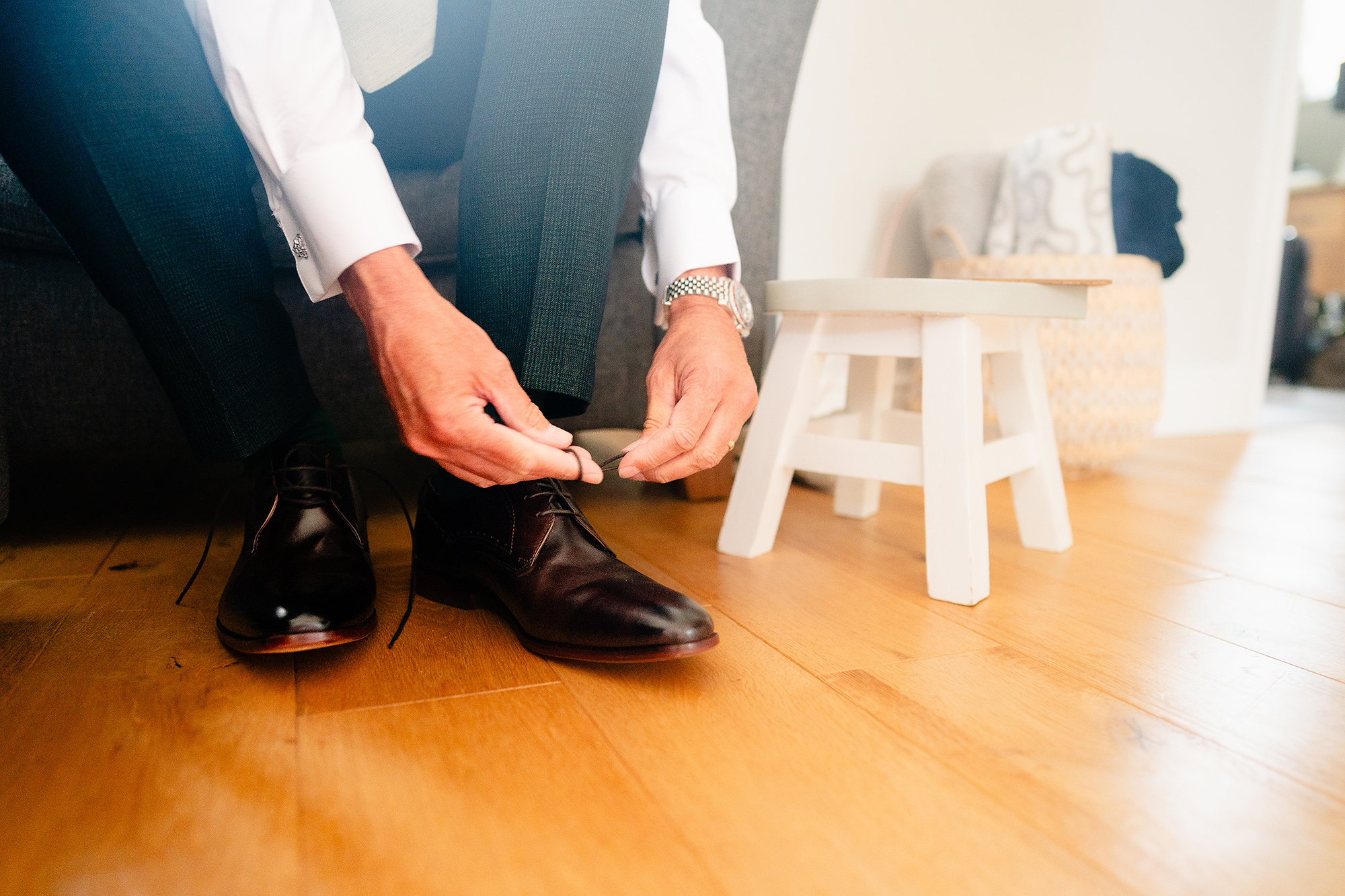 Pete lacing up his shoes in his green wedding suit on the morning of the wedding