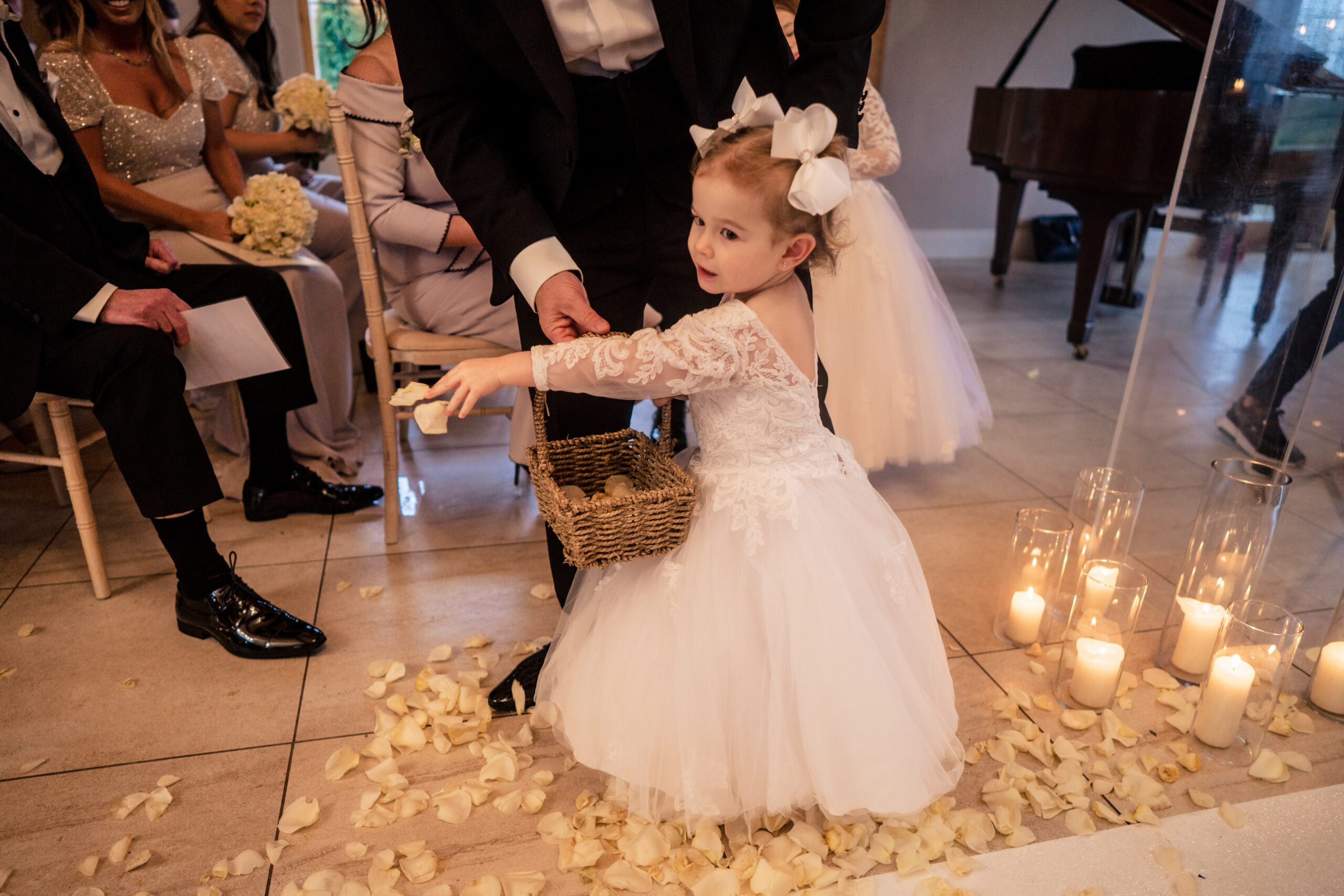 Little flower girl scattering petals from her basket beside the candles during the ceremony, Cheshire wedding photographer
