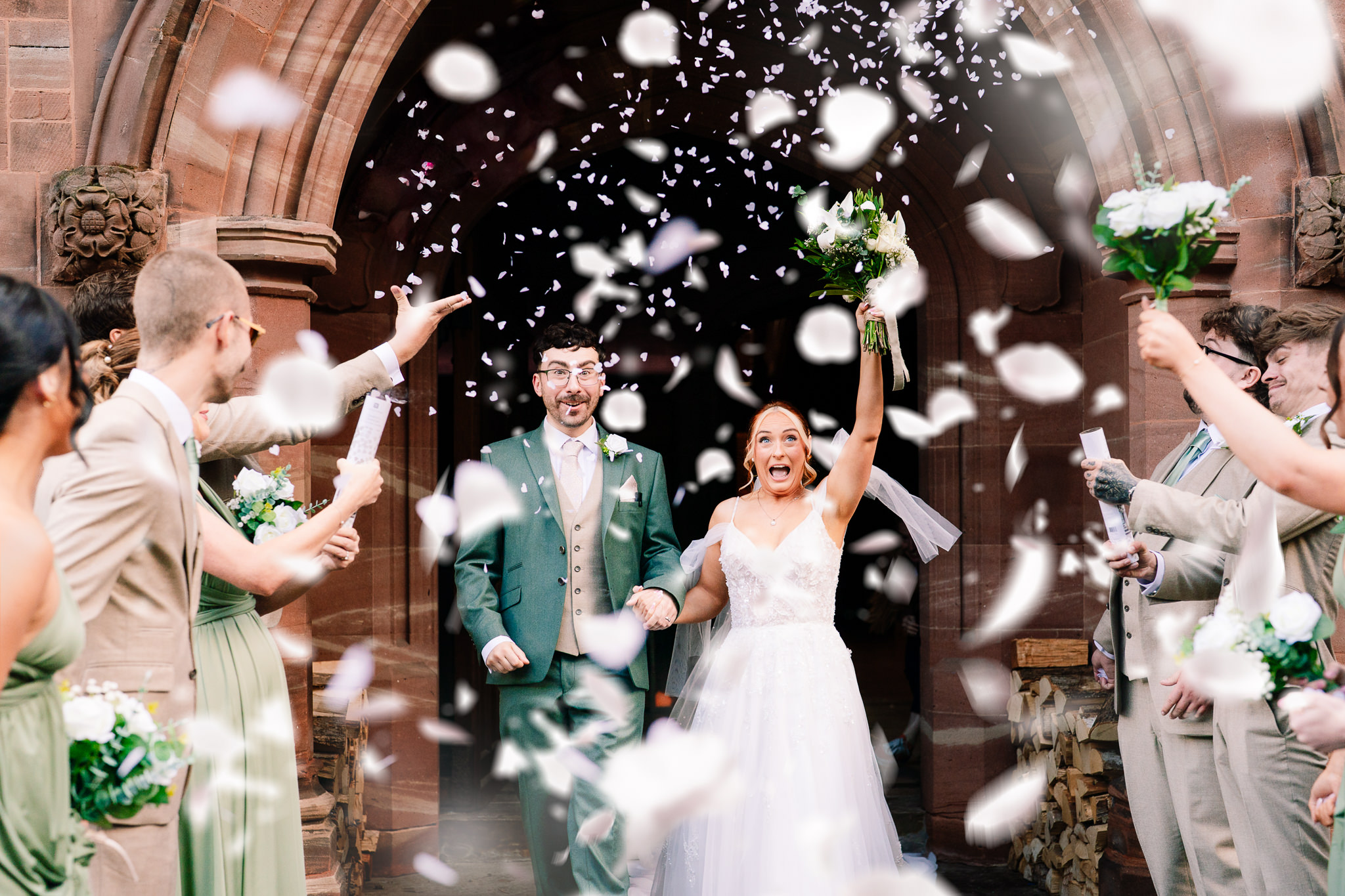 Confetti thrown over the bride and groom as they laugh together outside Salt House