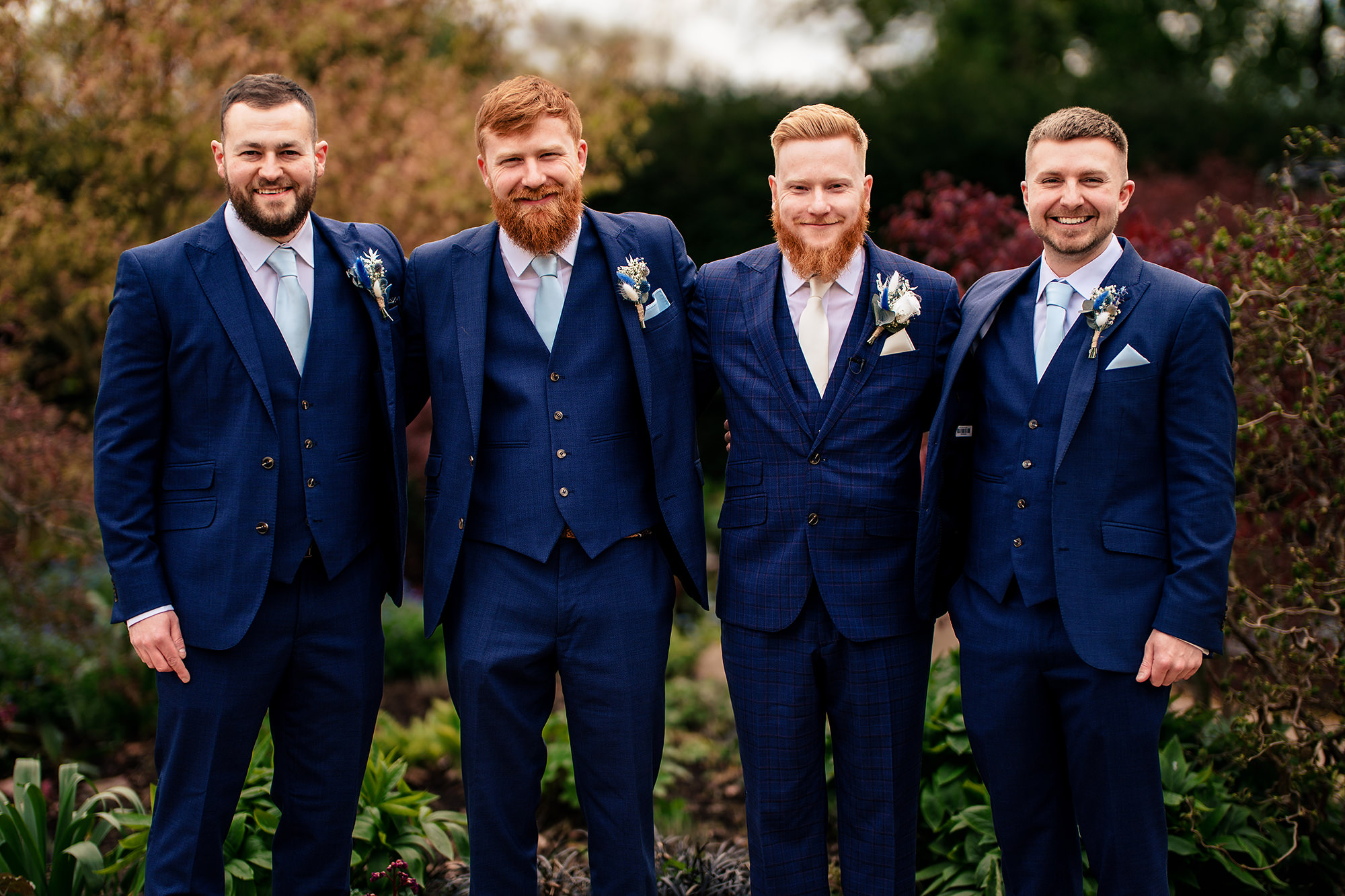 Groom and his groomsmen in navy suits in the Salt House gardens, Staffordshire wedding photographer
