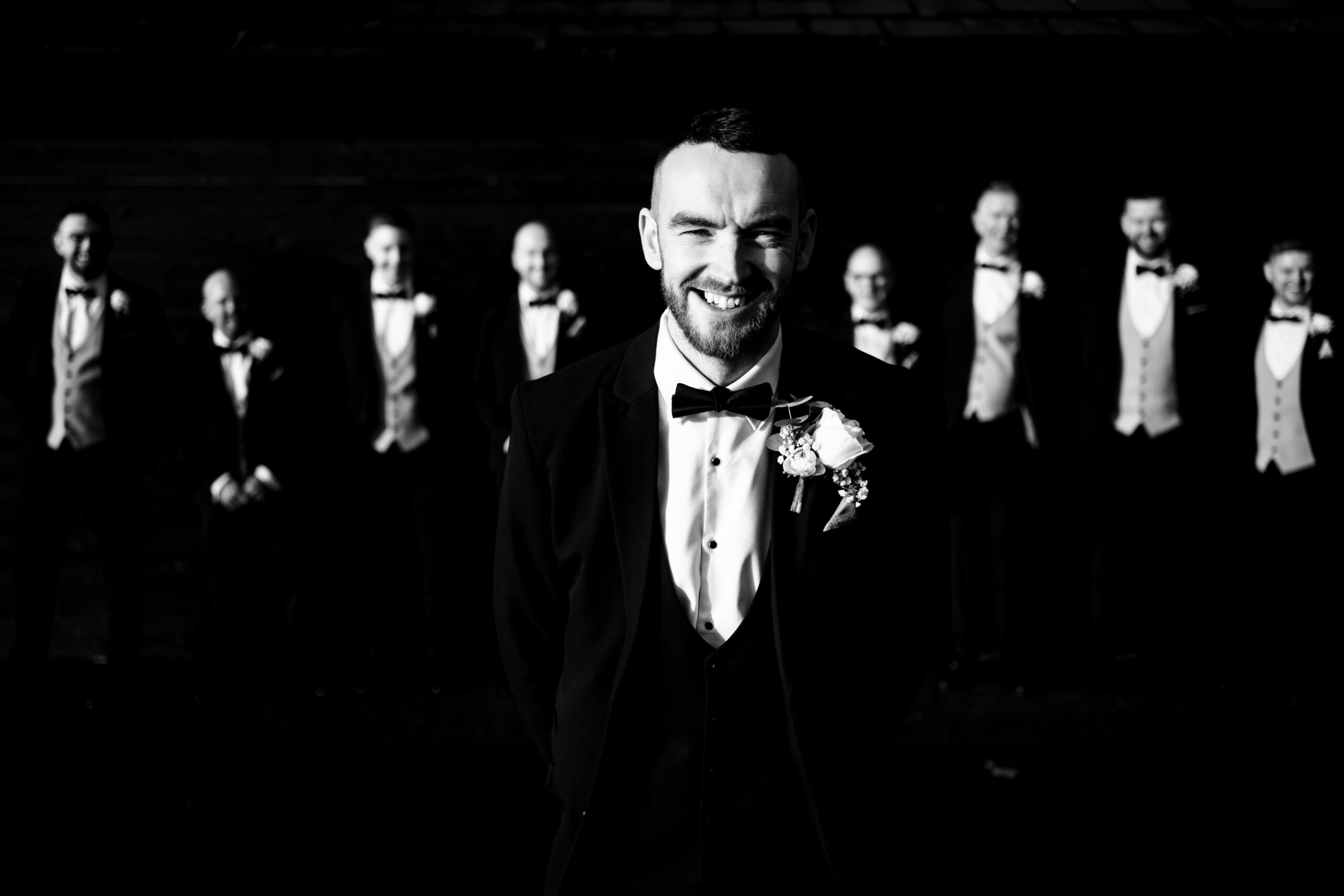 Joe walking past his groomsmen, all lined up and ready