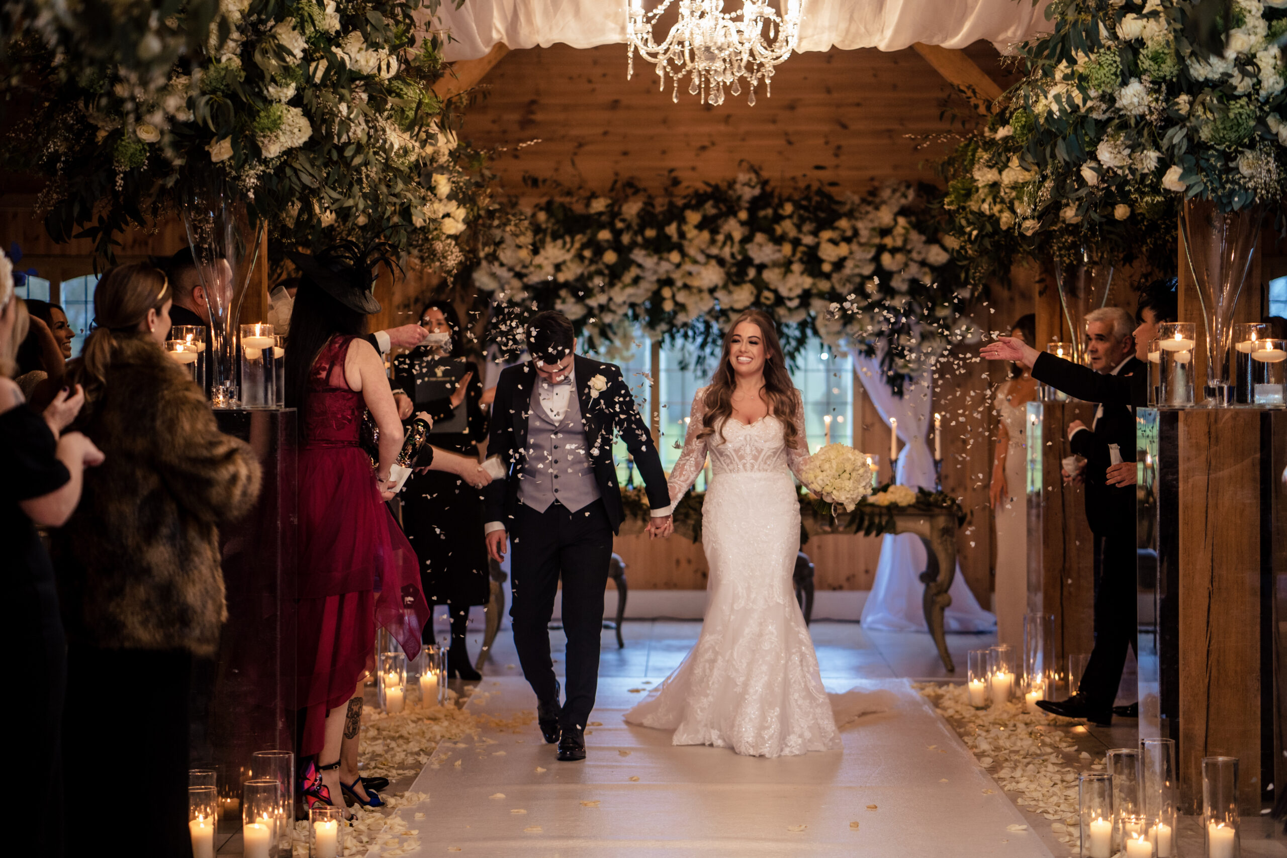 Abbie and Jamie walking back down the aisle through a shower of confetti at Merrydale Manor