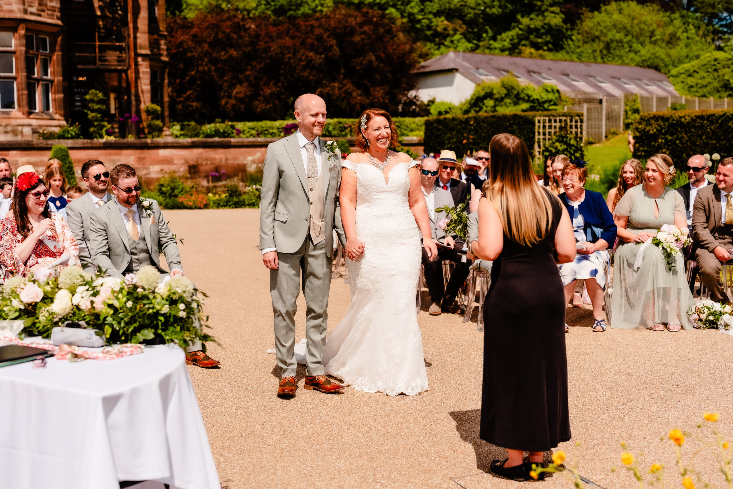 Bride and groom embracing during their outdoor wedding ceremony in the gardens at Salt House