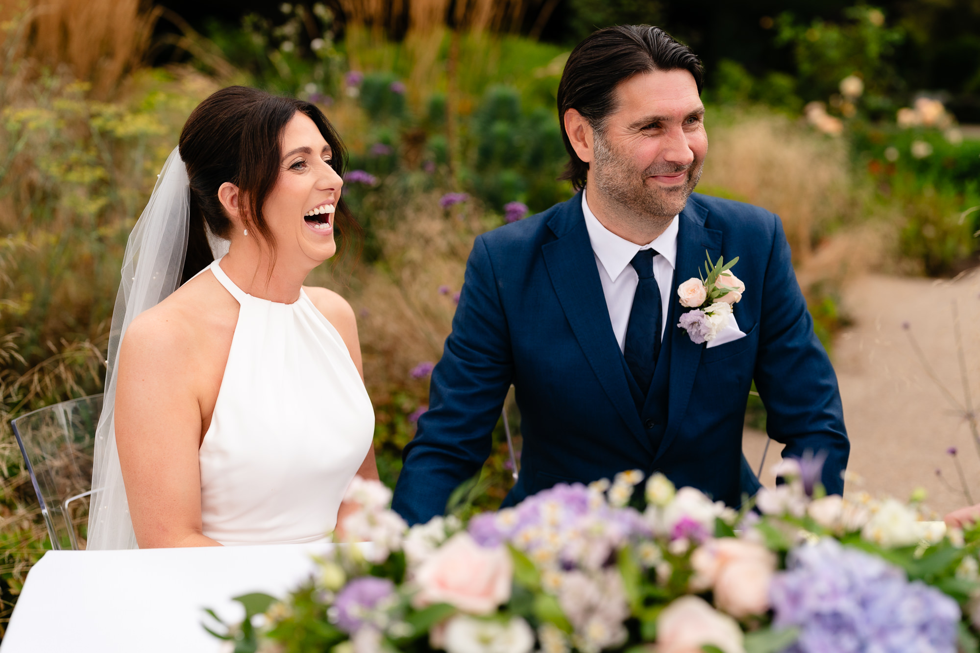 Bride laughing during the drinks reception in the gardens at Salt House, Staffordshire wedding photographer