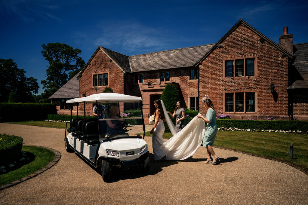 Gemma’s mum carrying her train as they head to a golf buggy outside the manor house at Merrydale Manor
