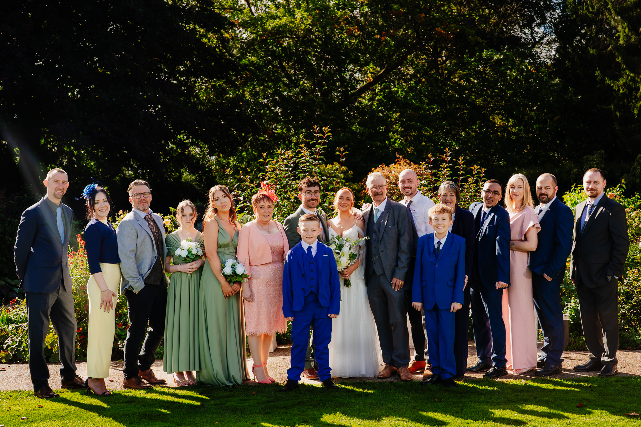 The whole wedding party and family gathered together for a group photo on the lawn at Salt House