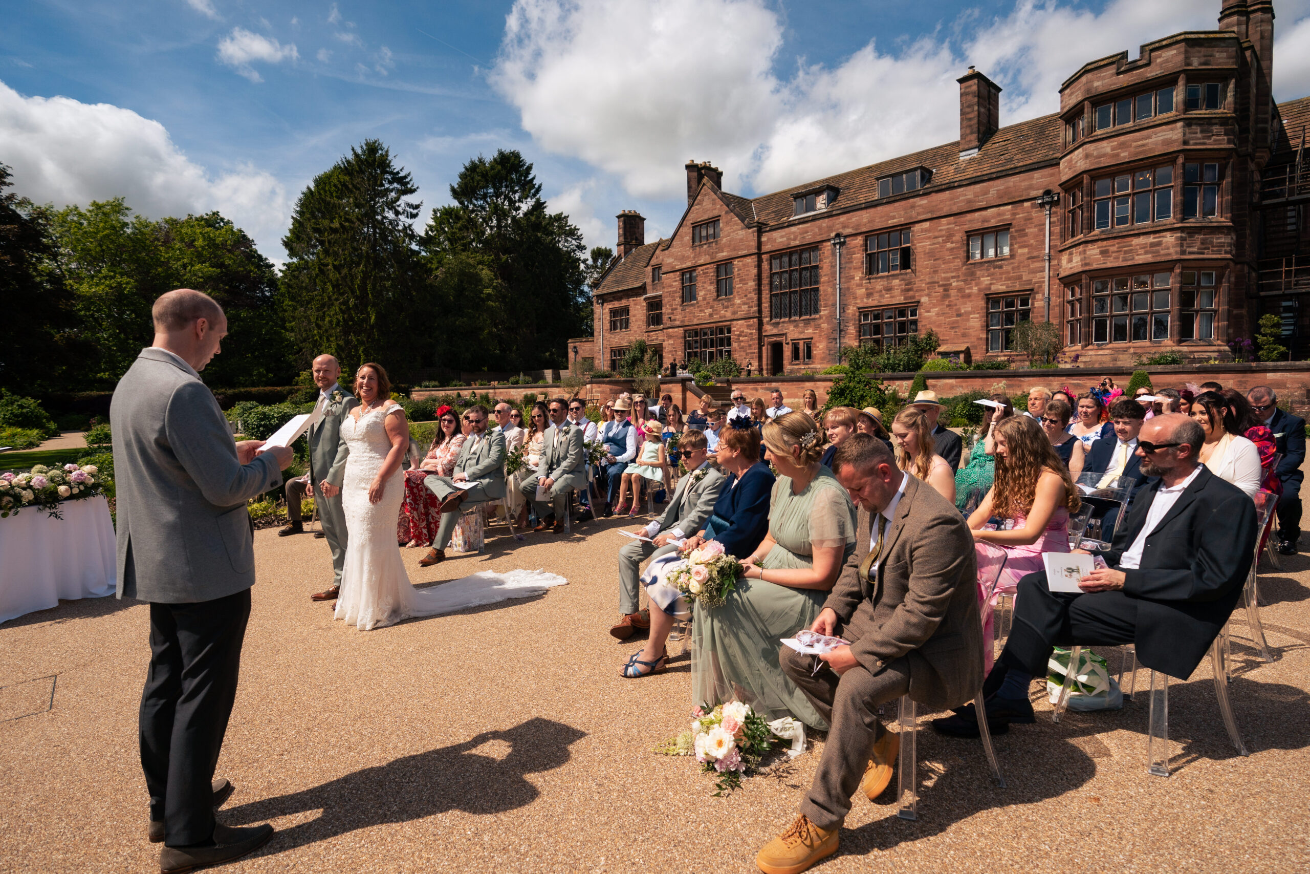 Bride and groom exchanging vows in front of the celebrant during their outdoor ceremony at Salt House