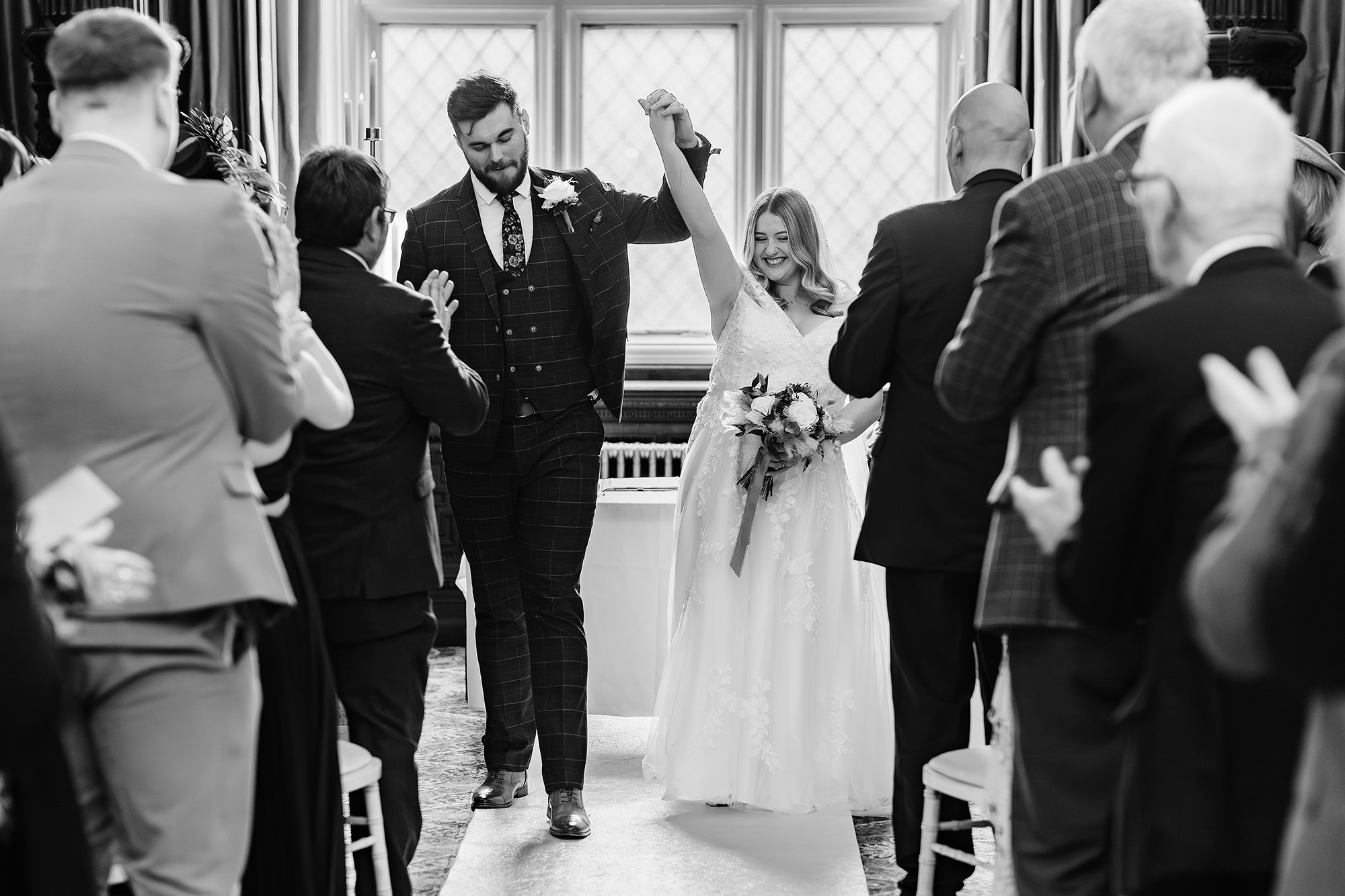 Black and white shot of the newlyweds and guests filing out of the ceremony room, Crewe Hall wedding photographer