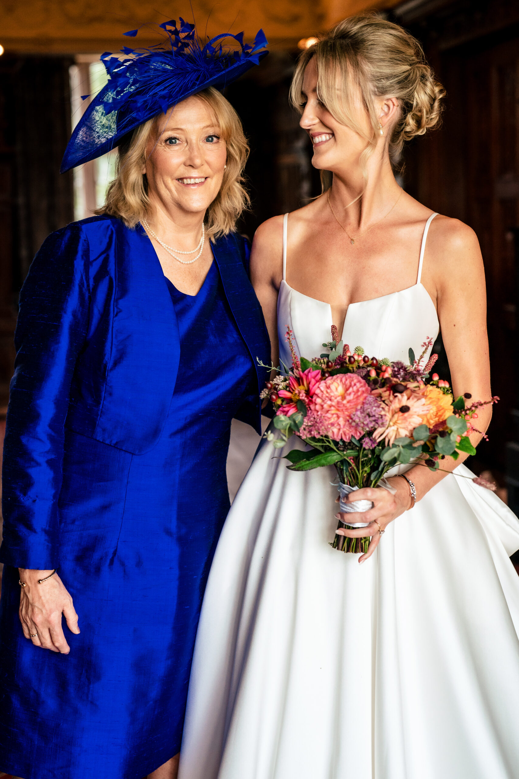 Bride standing with her mum in a cobalt blue outfit before the ceremony, Dorfold Hall wedding photographer