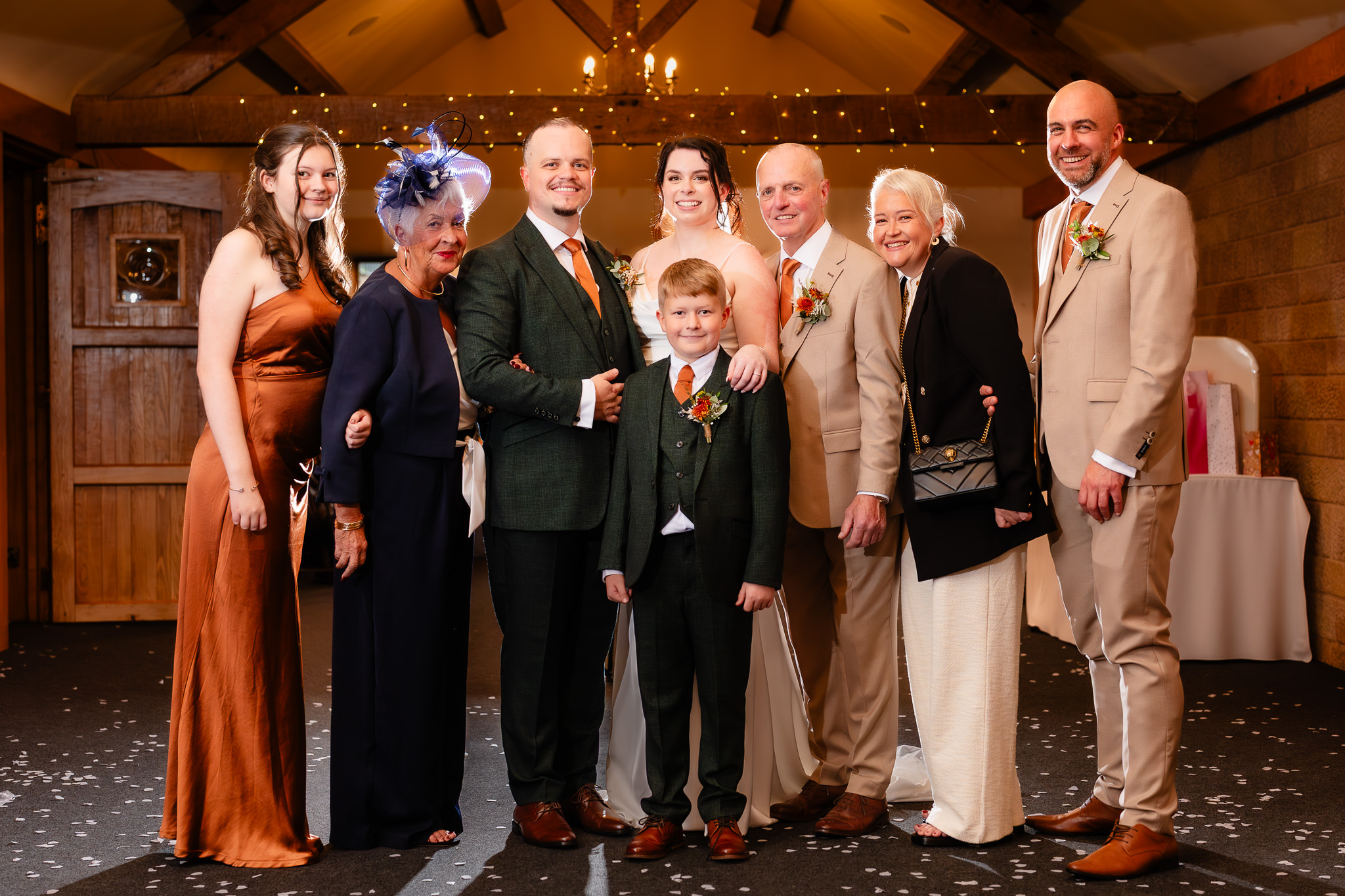 Family group photo with the page boy in a green three piece suit standing in front of the couple, Heaton House Farm wedding