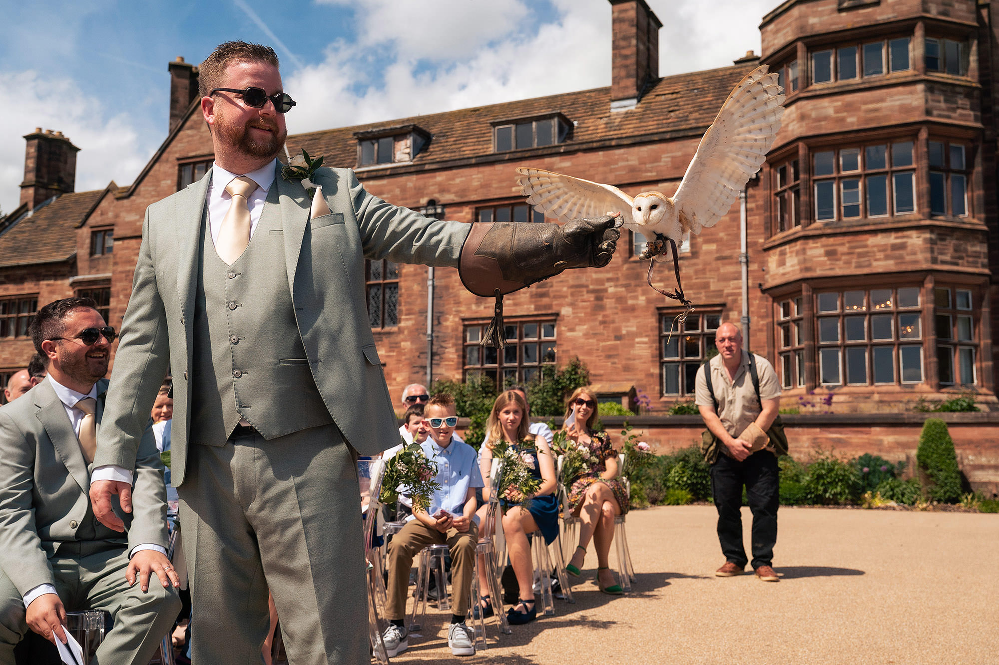 A barn owl flying in to deliver the wedding rings during the ceremony at Salt House, watched by seated guests