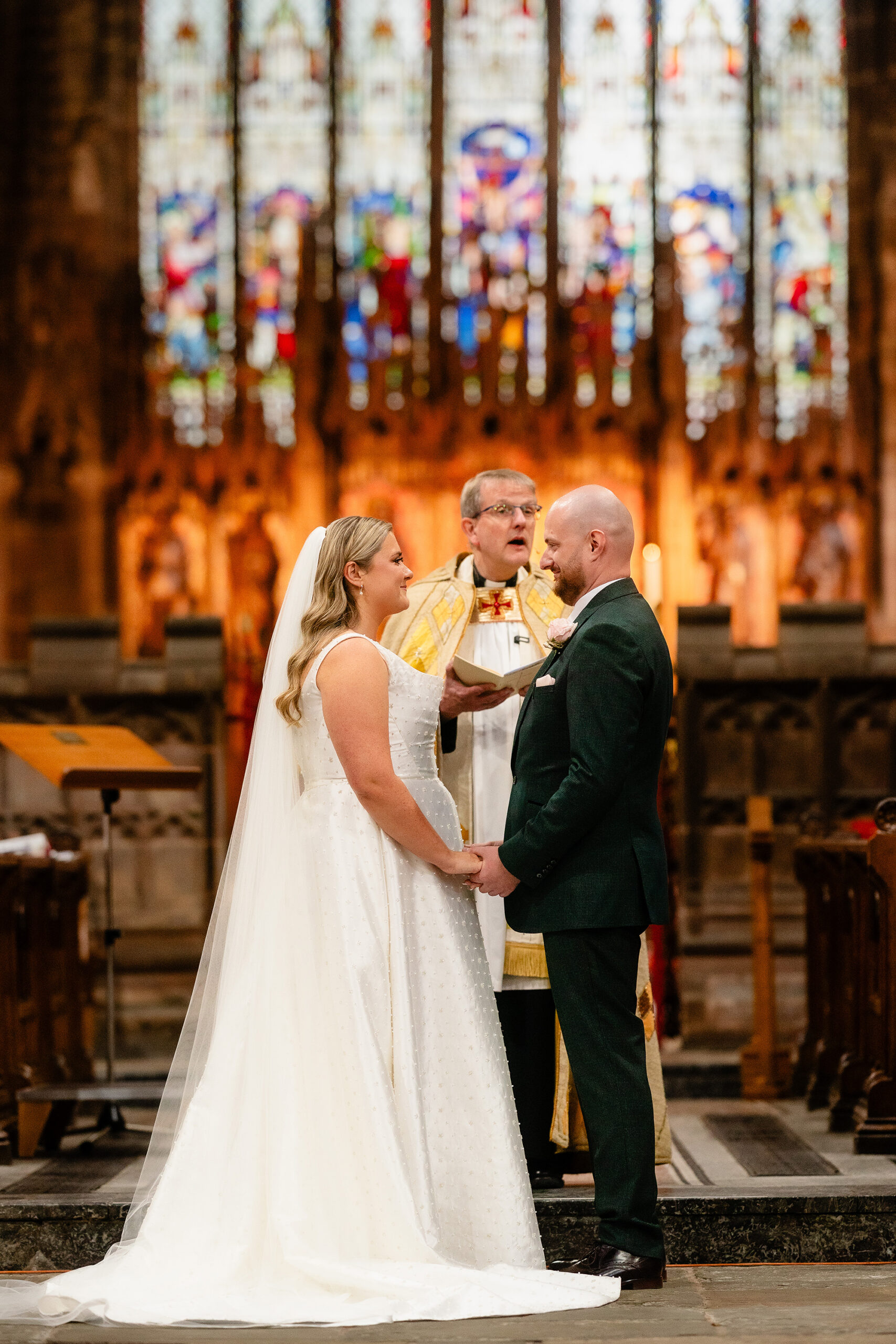 Chloe and Pete exchanging vows in front of St Mary’s Church’s stunning stained glass