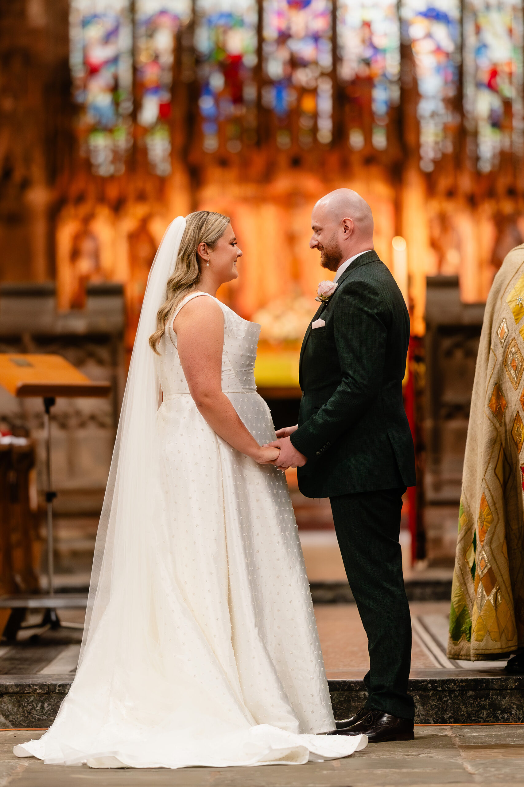 Chloe and Pete holding hands during their wedding ceremony at St Mary’s Church