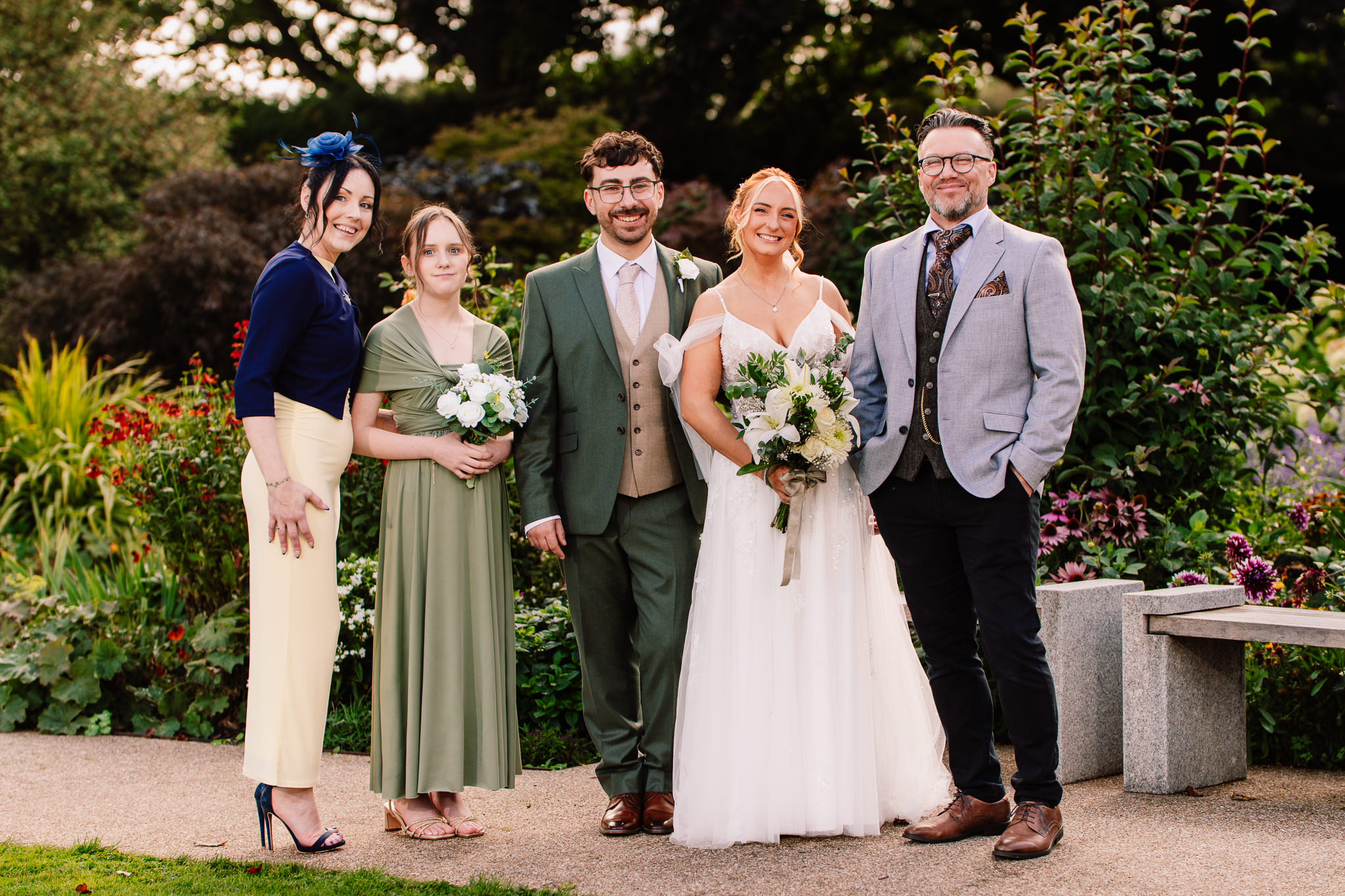 Bride and groom with extended family members posing together in the gardens