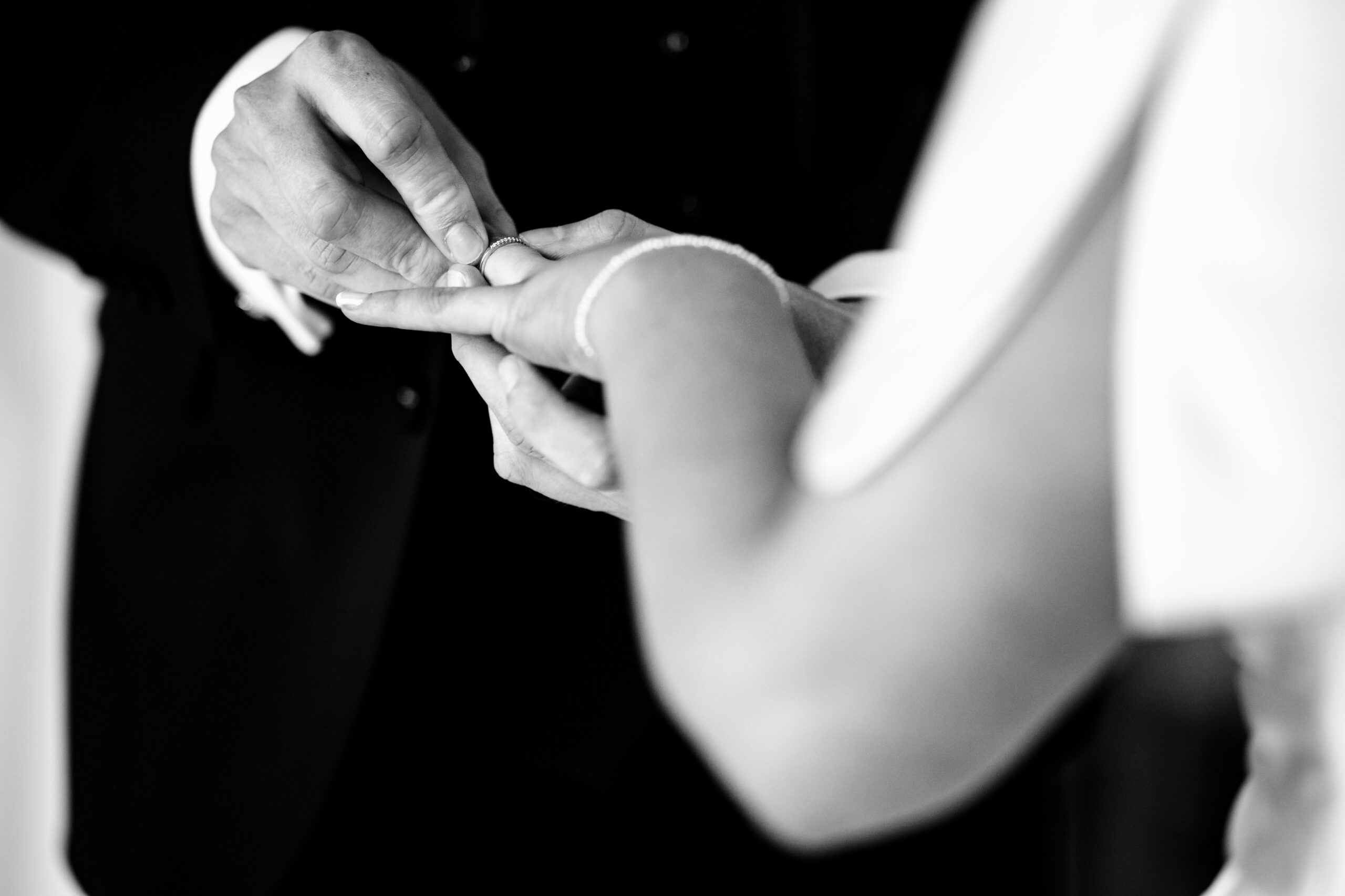 A close up of the ring going on during the ceremony