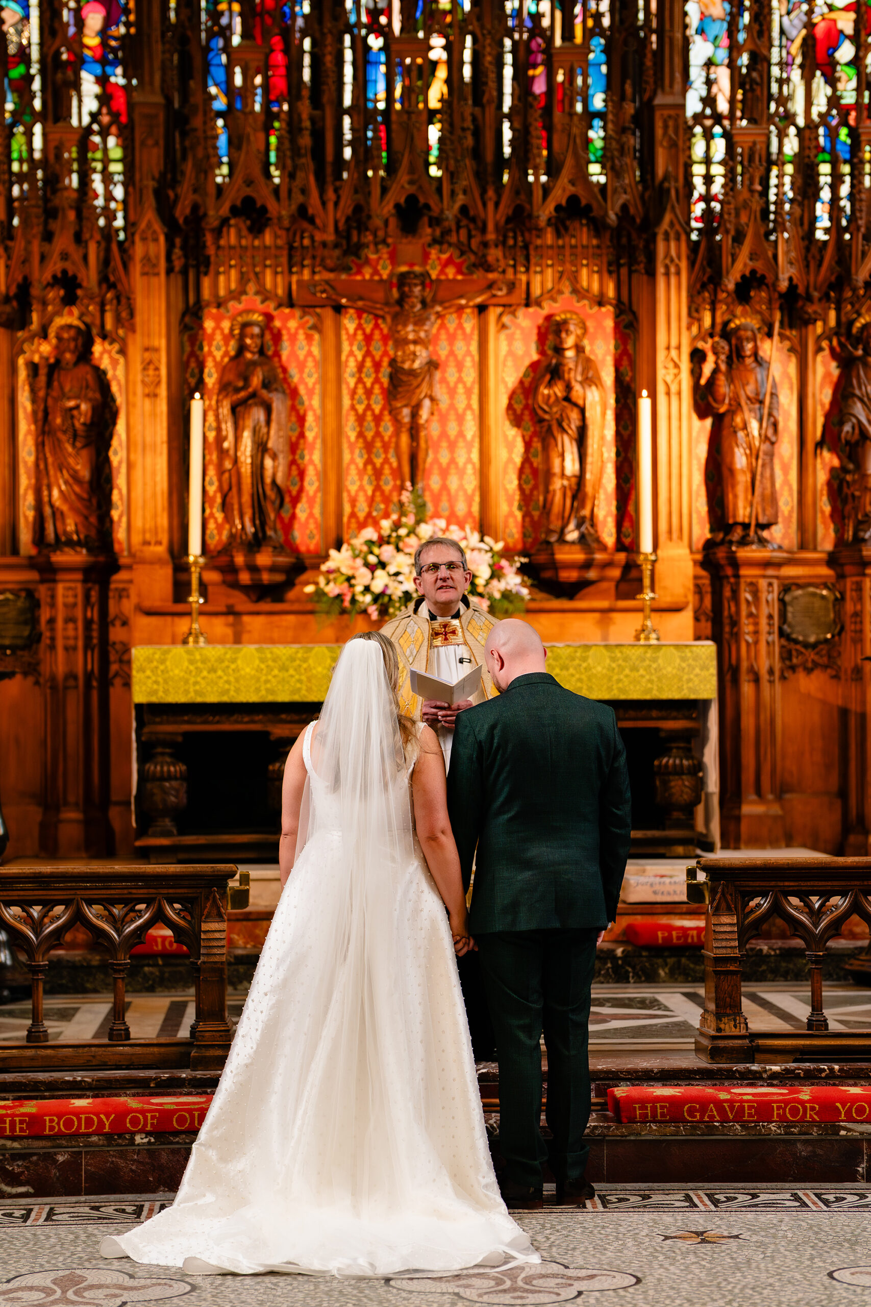 A wide shot of the altar and the church’s huge stained glass window during the ceremony