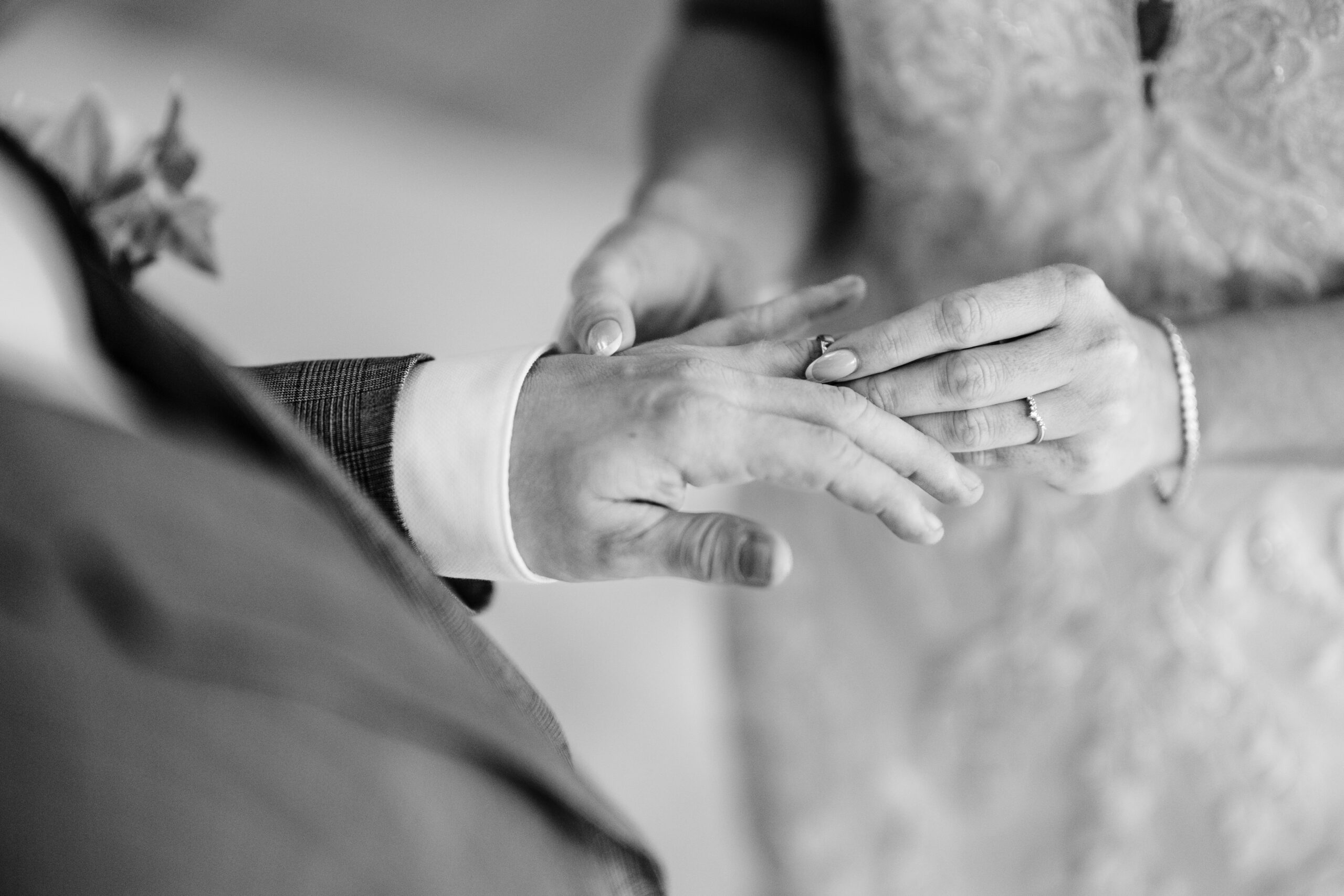 Black and white close up of the wedding ring being slid onto the bride's finger, Cheshire wedding photographer