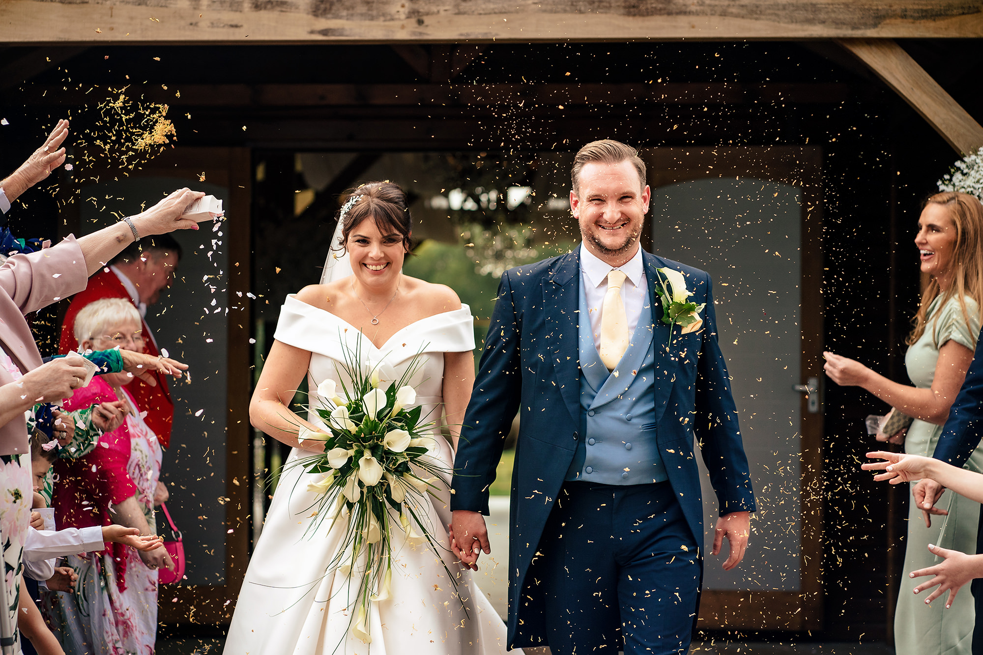 Laura and Ryan stepping out through gold confetti as newlyweds, Merrydale Manor wedding photographer